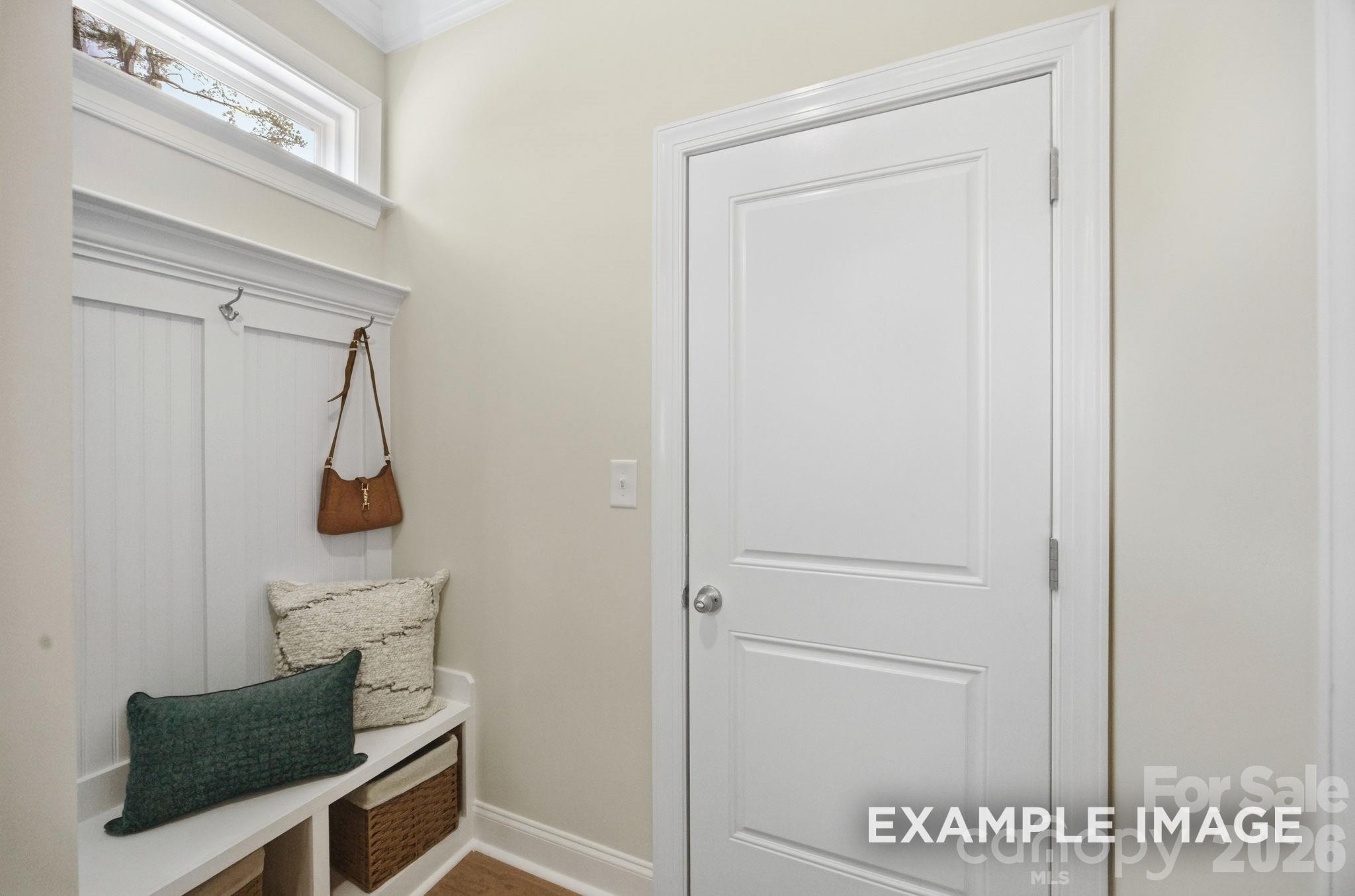 Mudroom drop zone with built-in bench, storage baskets, and coat hooks in The Hickory B II plan, Windgate, Mooresville, NC.