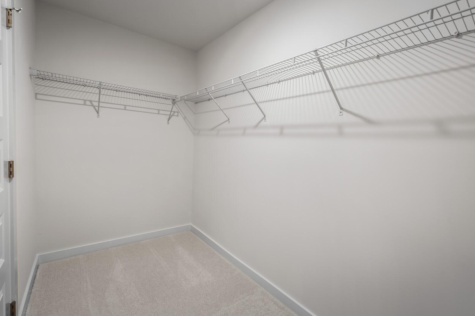 Spacious walk-in closet with white wire shelving in The Willow floor plan at Woods Crossing, Gallatin, Tennessee.