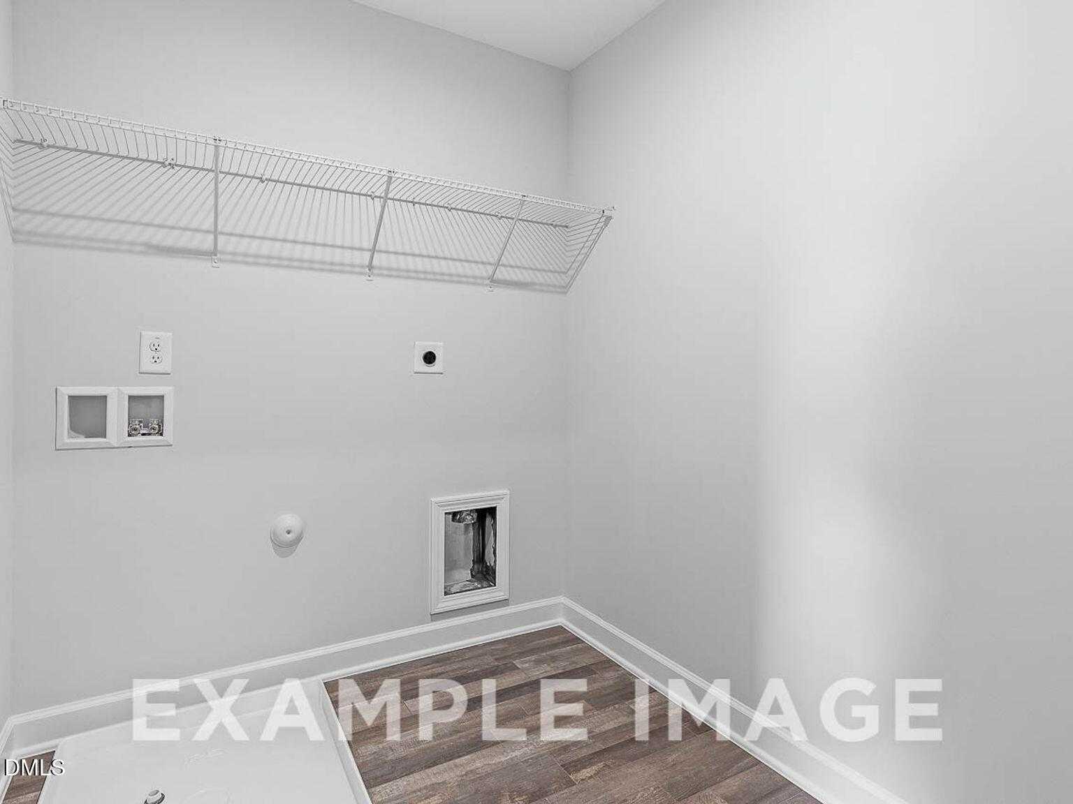 Bright laundry room with wire shelving, pet door, outlets and luxury vinyl plank flooring in The Chestnut B by Davidson Homes, Lillington, NC