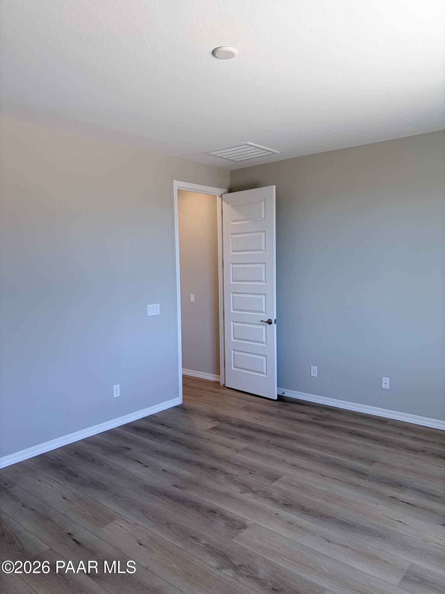 Neutral bedroom with wood-look flooring in The Frontier A floor plan by Davidson Homes at North Ridge, Prescott Valley.