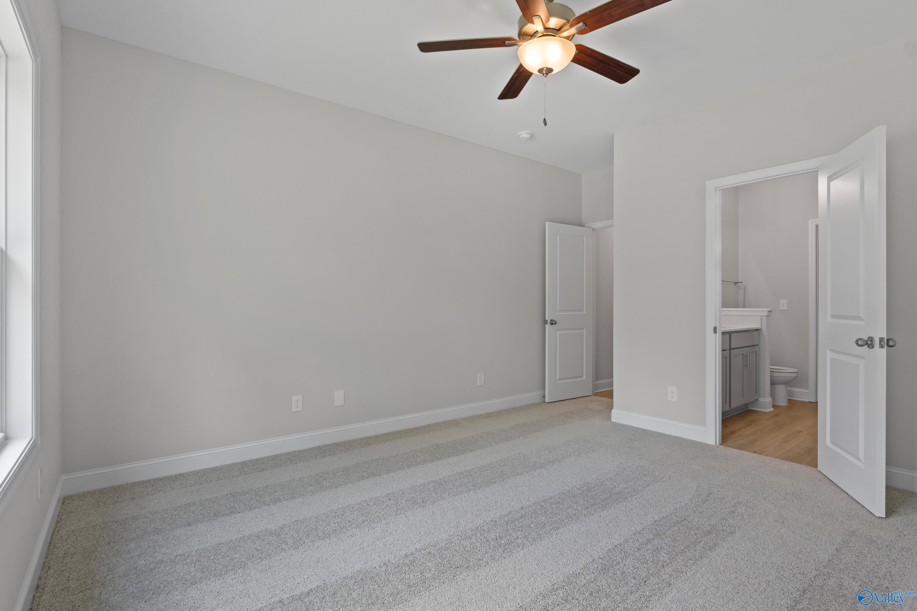 Bright secondary bedroom with gray walls, beige carpet, ceiling fan, and attached bath in The Asheville, Spragins Cove, Huntsville AL