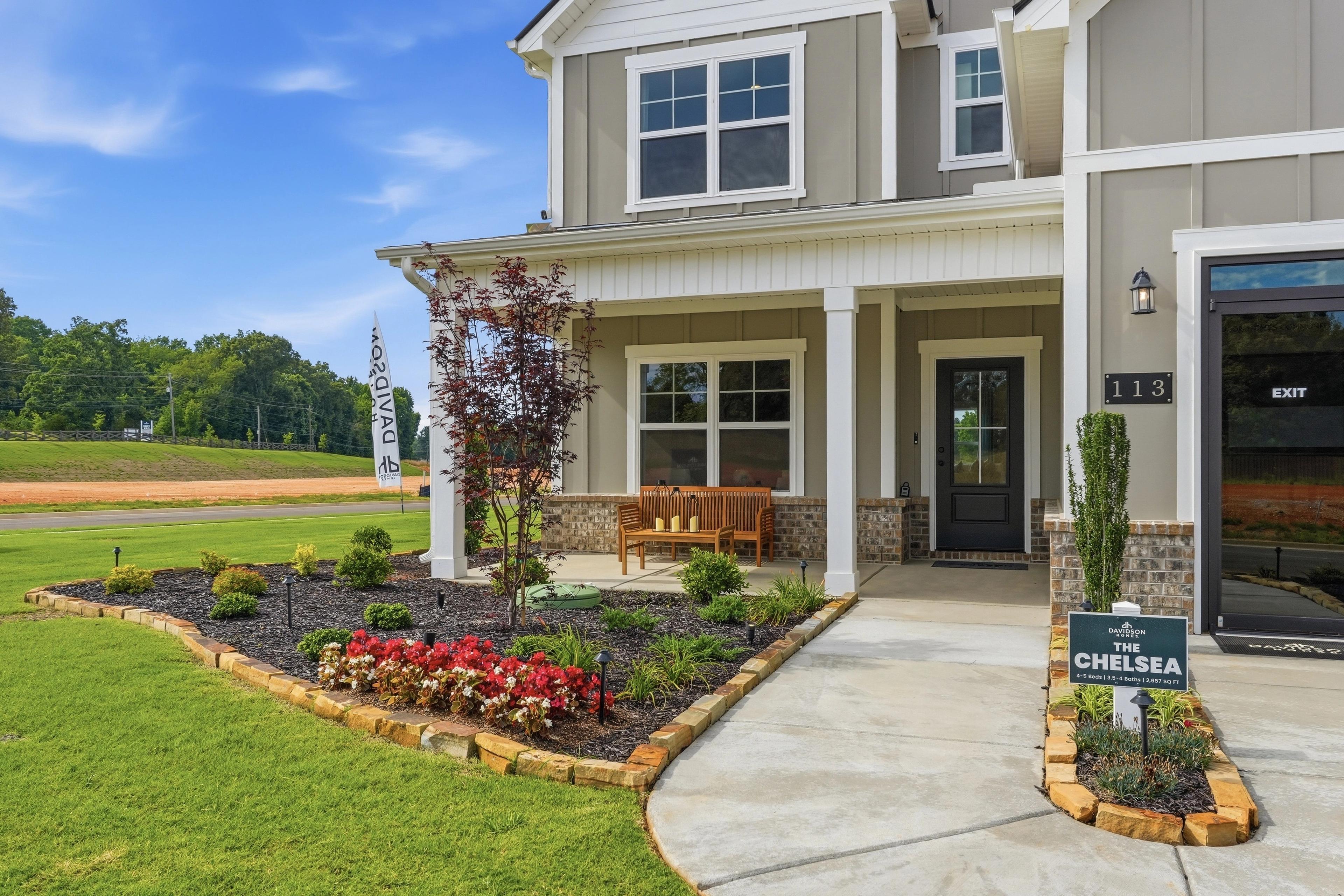 The Chelsea model home exterior at Berry Cove in New Market, Alabama, featuring a covered porch and landscaped yard.
