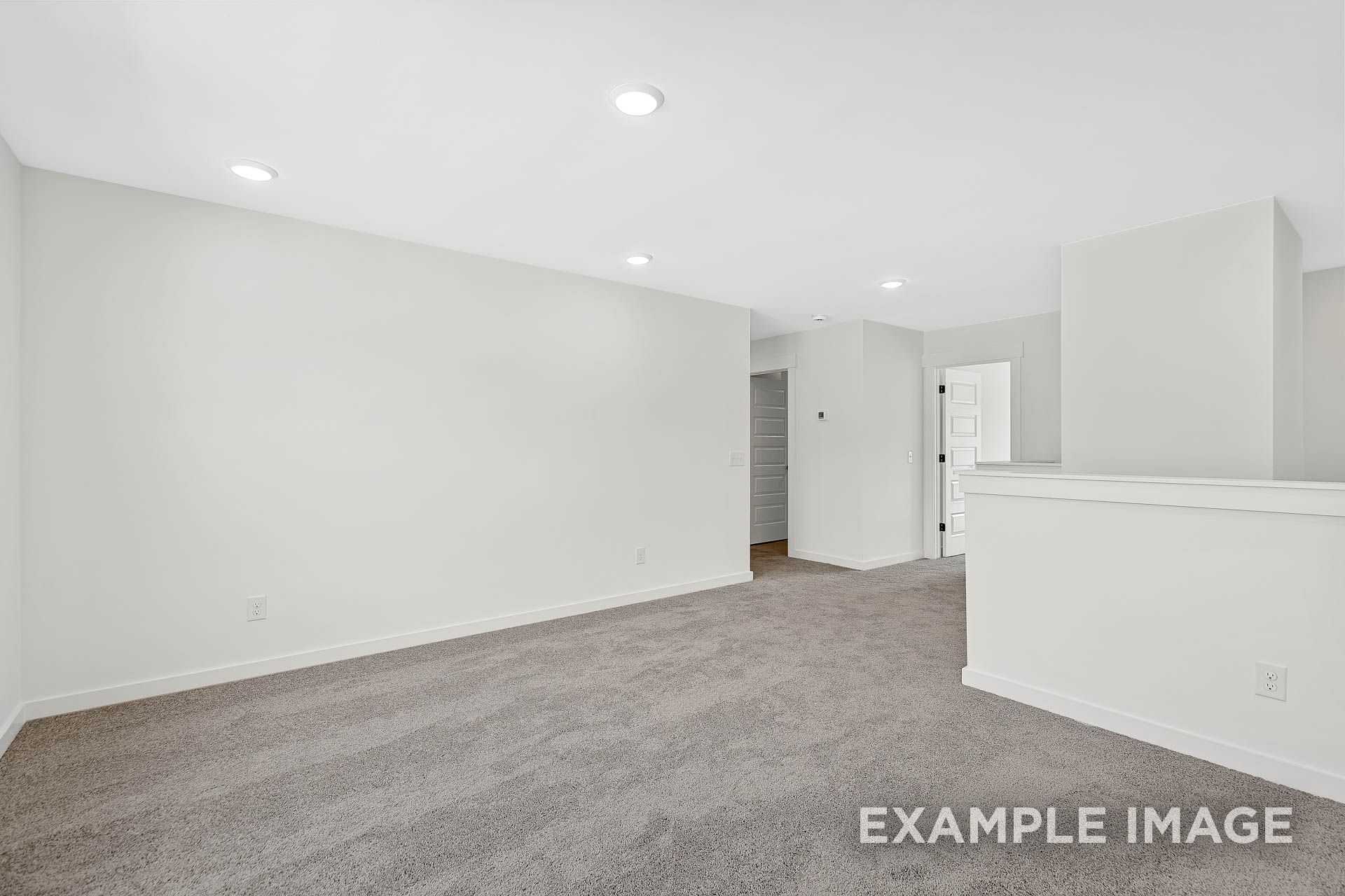 Spacious upper floor hallway in The Logan B with gray carpet, white walls, recessed lights, and open loft railing