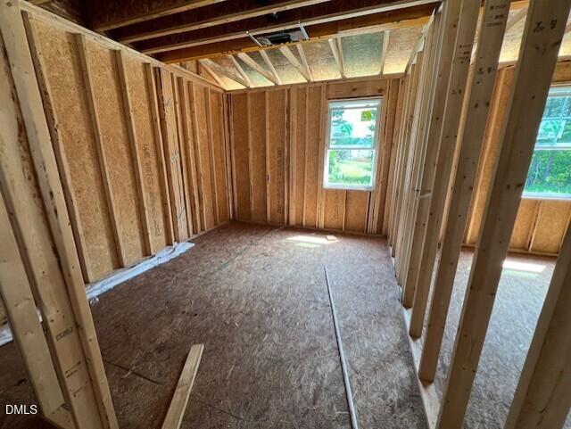 Unfinished bedroom framing with wooden wall studs and subfloor in The Willow D floor plan at Wellers Knoll, Lillington, NC.