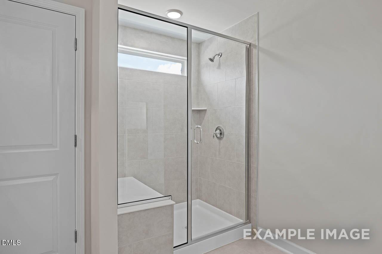 Modern walk-in tiled shower with glass door in The Graham floor plan by Davidson Homes in Springvale, Fuquay-Varina, NC.