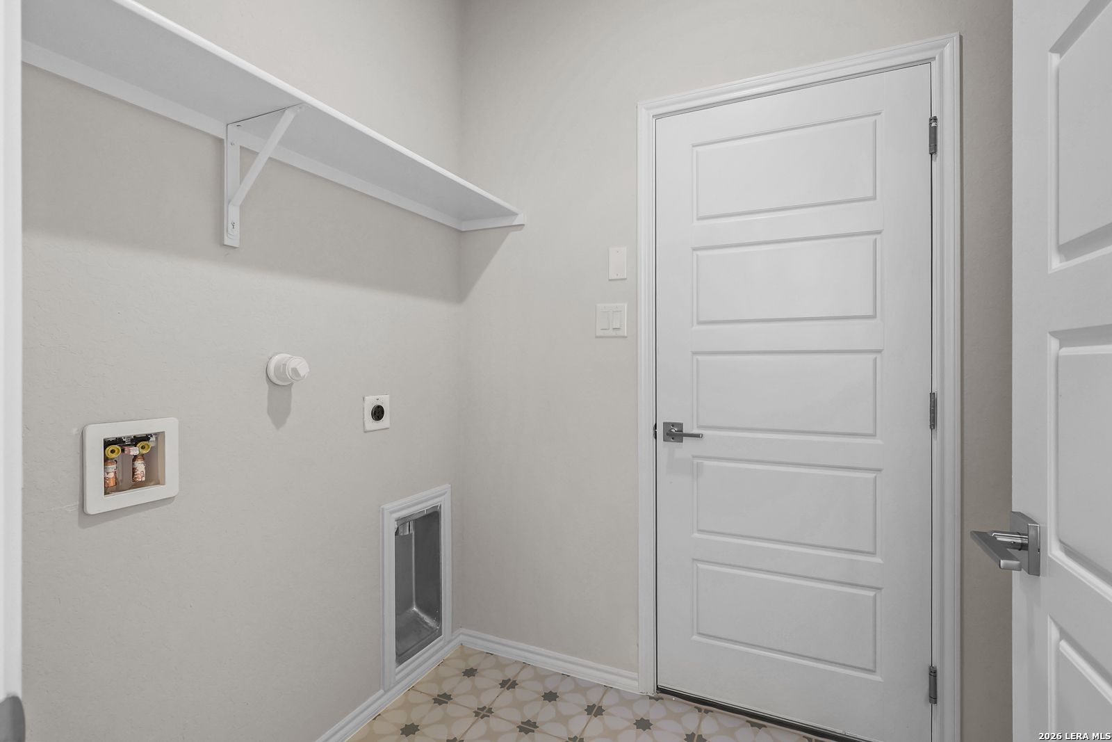 Laundry room with utility connections and built-in shelving in The San Marcos F floor plan at Rayburn Valley, San Antonio.