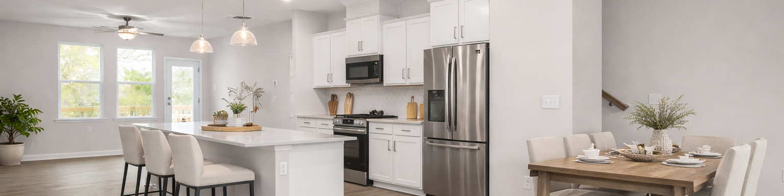 Modern kitchen at Forestville Yard Townhomes in Knightdale NC featuring white cabinets, stainless steel gas range, and herringbone tile backsplash