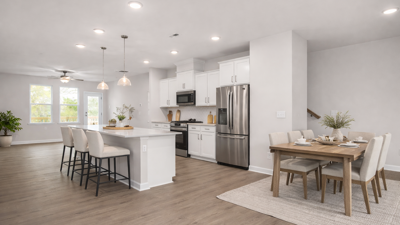 Modern kitchen at Forestville Yard Townhomes in Knightdale NC featuring white cabinets, stainless steel gas range, and herringbone tile backsplash