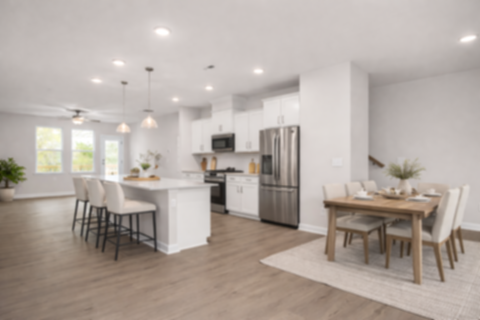Modern kitchen at Forestville Yard Townhomes in Knightdale NC featuring white cabinets, stainless steel gas range, and herringbone tile backsplash