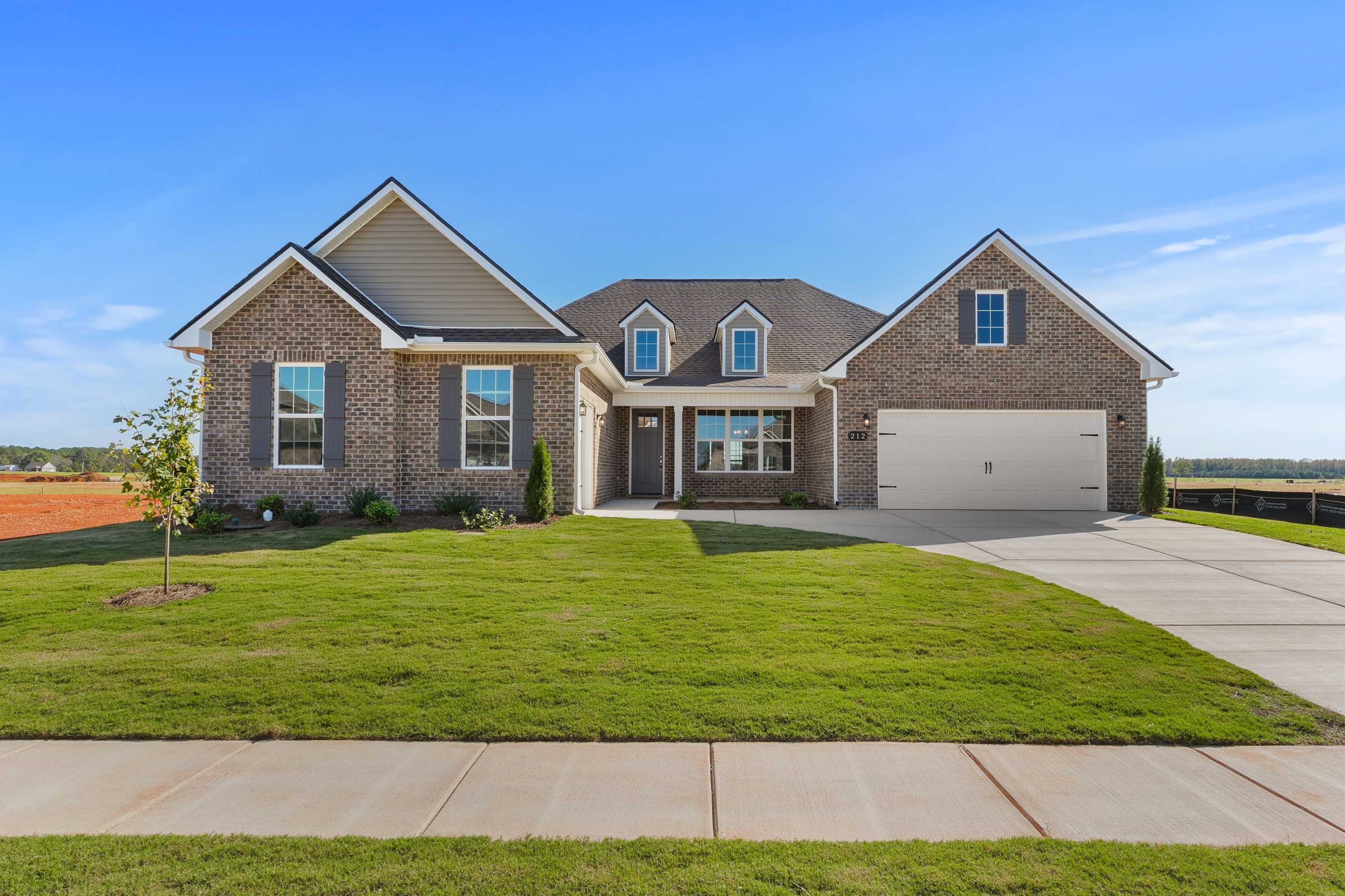 Modern single-story The Valencia home by Davidson Homes featuring brick and siding exterior, 3-car garage, and lush front yard in Meridianville, AL