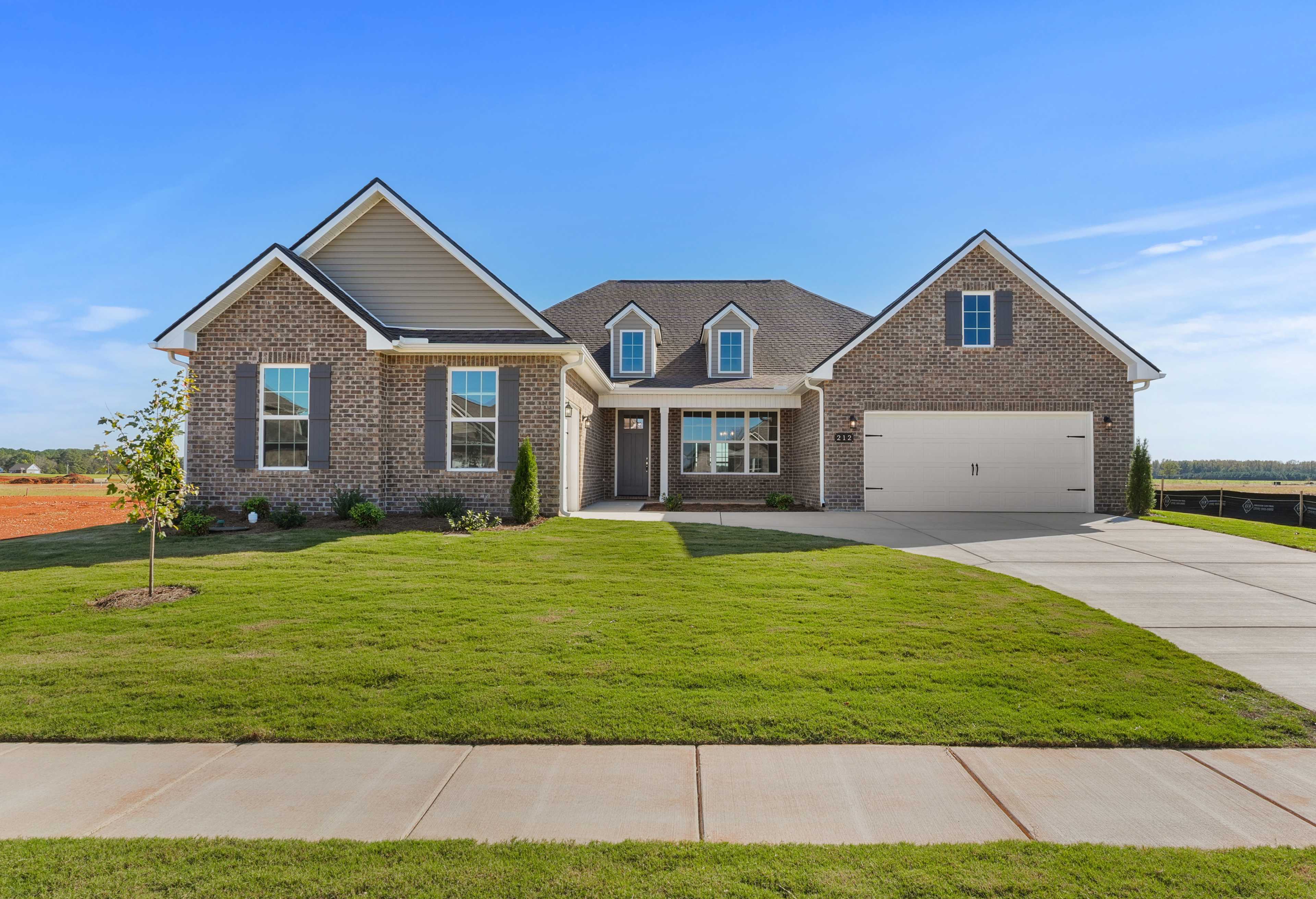 Modern single-story The Valencia home by Davidson Homes featuring brick and siding exterior, 3-car garage, and lush front yard in Meridianville, AL