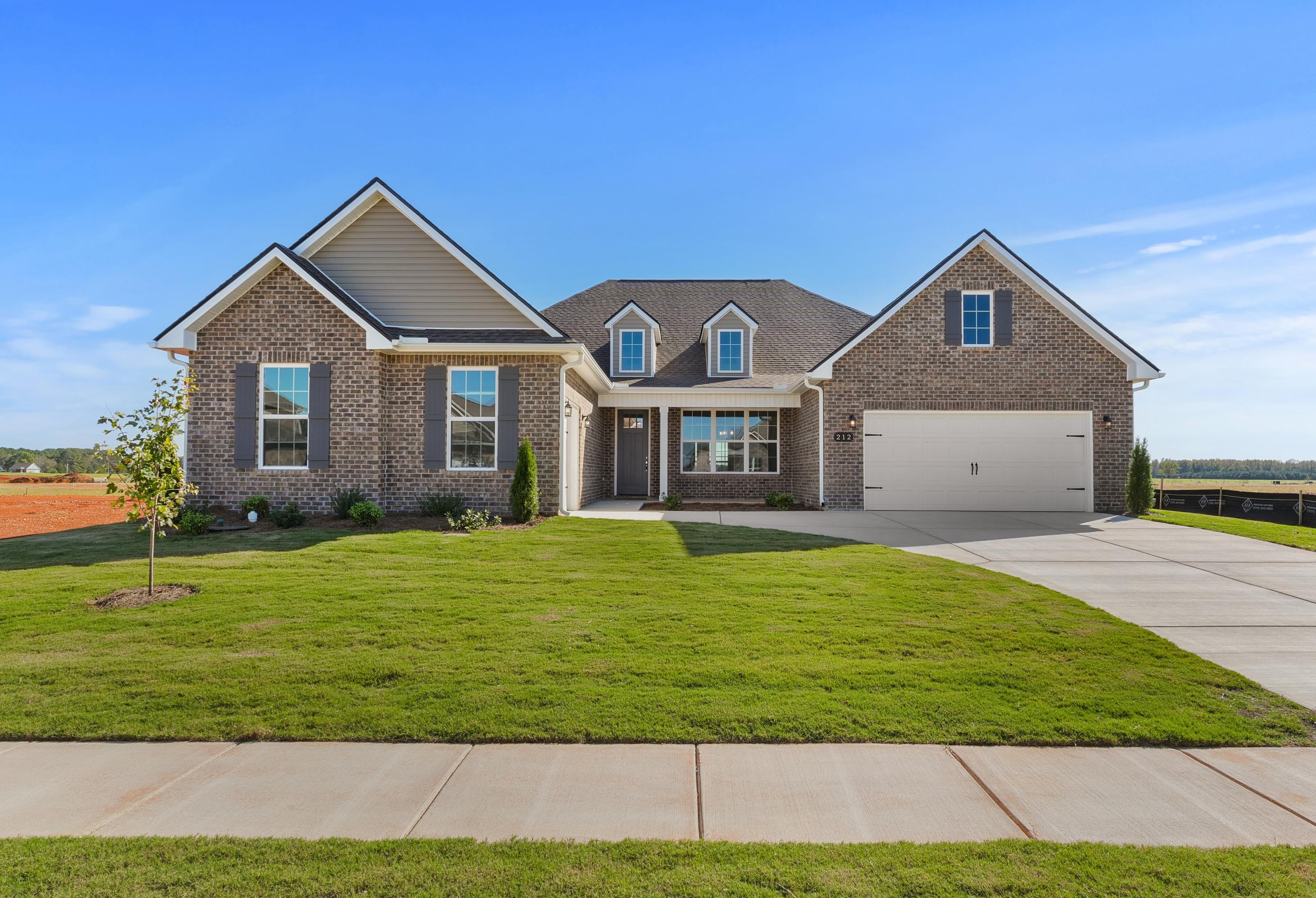 Modern single-story The Valencia home by Davidson Homes featuring brick and siding exterior, 3-car garage, and lush front yard in Meridianville, AL