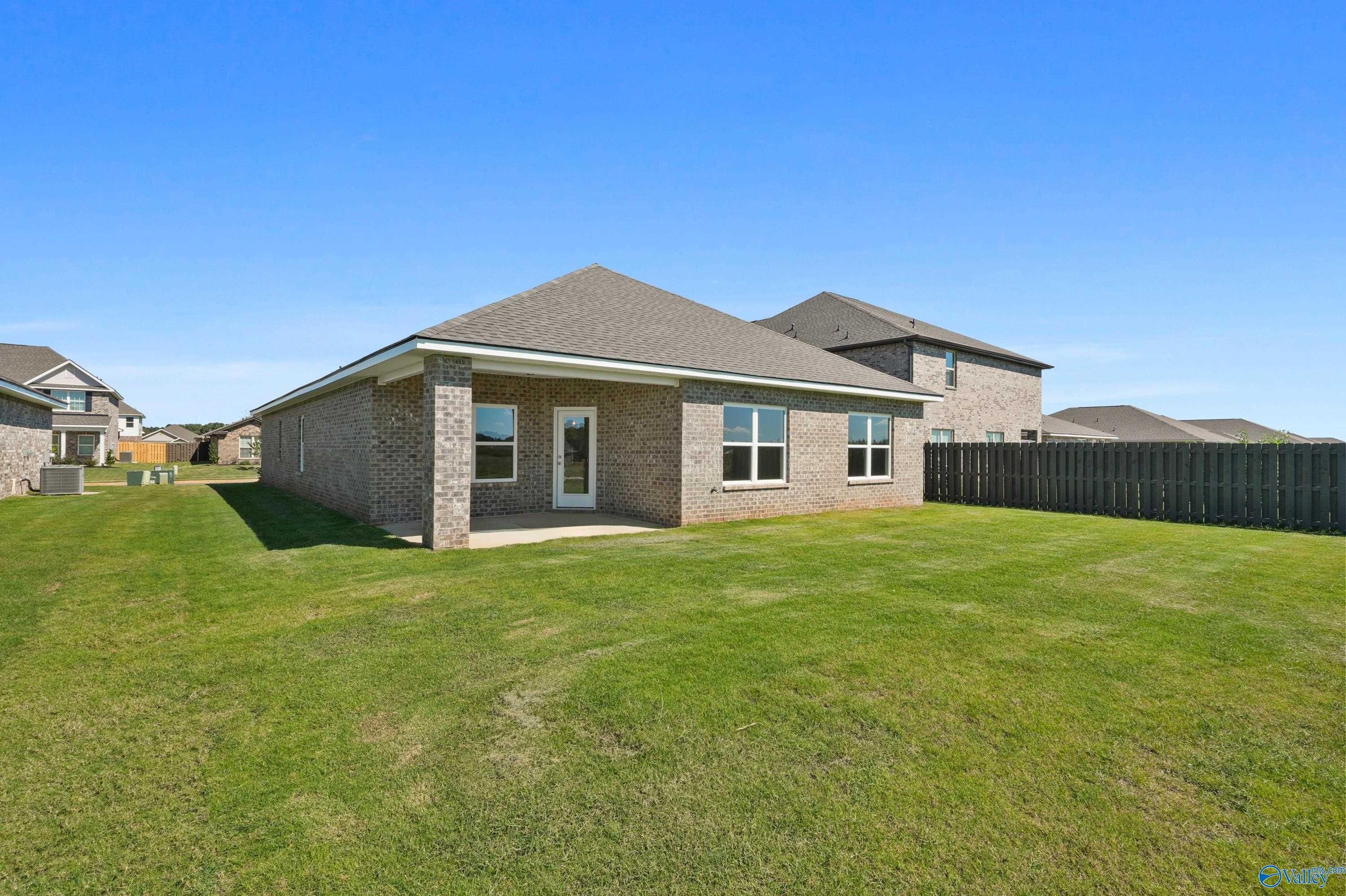 Single-story brick Everett home with gabled roof, large fenced backyard, and green lawn in Clearview, Hazel Green, Alabama