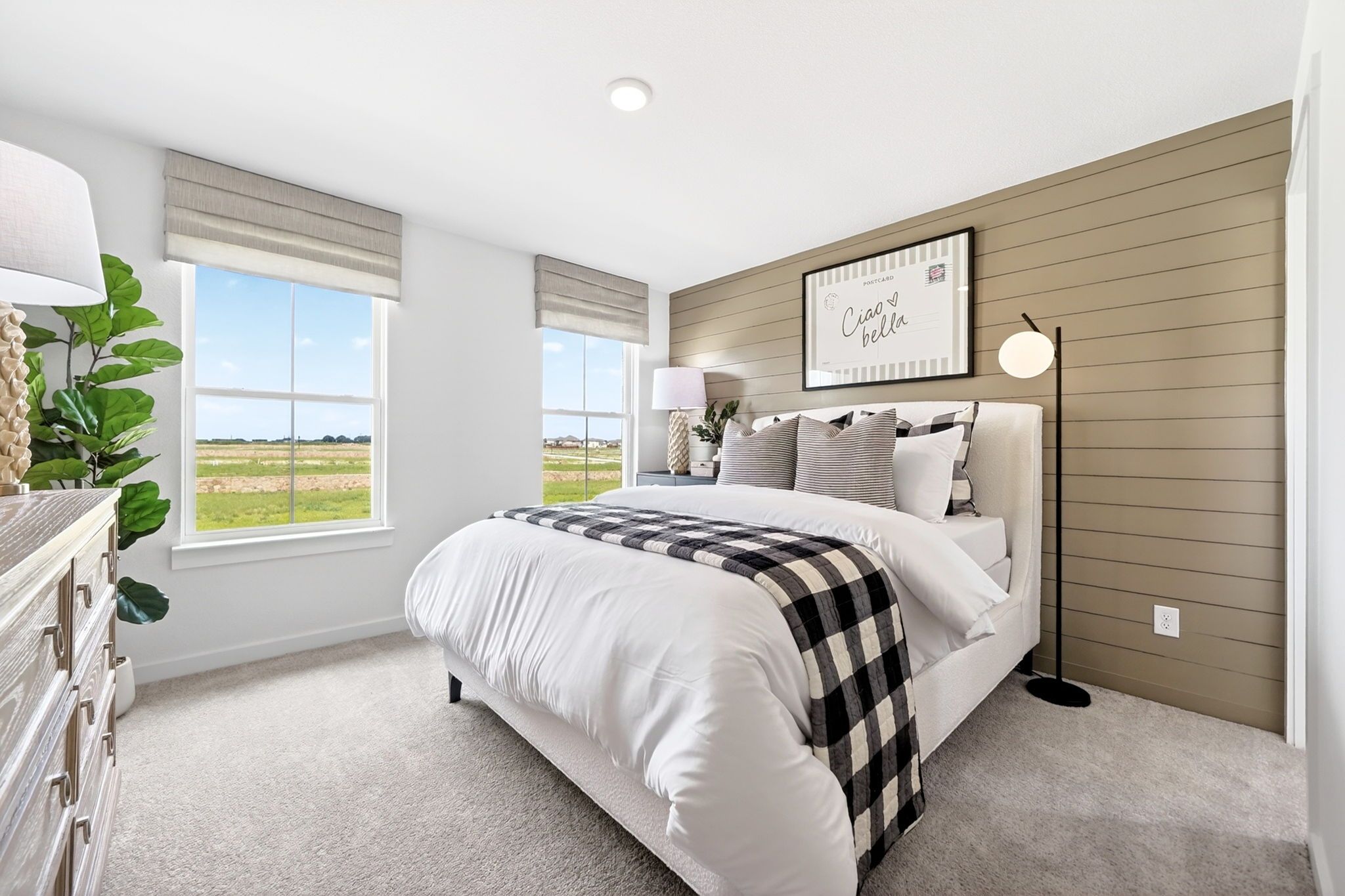 Modern bedroom at Parks at Foster Crossing in Anna, TX featuring a shiplap accent wall, upholstered bed, and cozy decor.