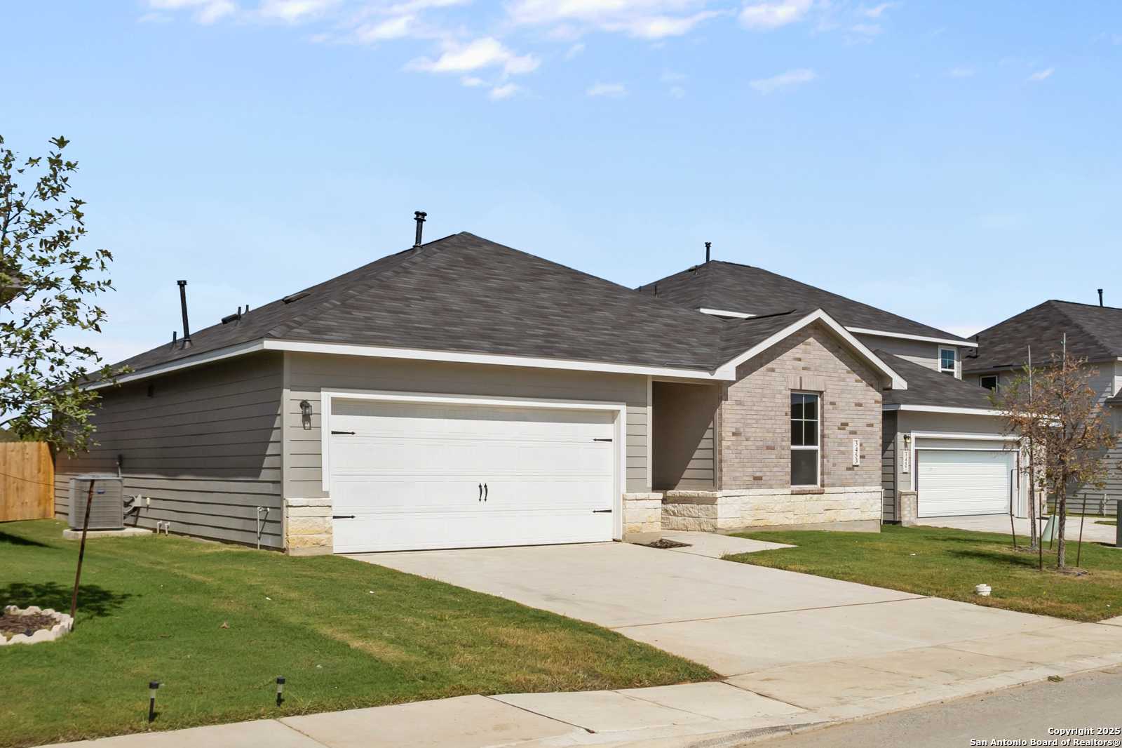 Modern 1-story Davidson Homes The Asheville H with gray siding, brick accents, 2-car garage, driveway, and landscaped yard in Horizon Pointe, Converse, Texas
