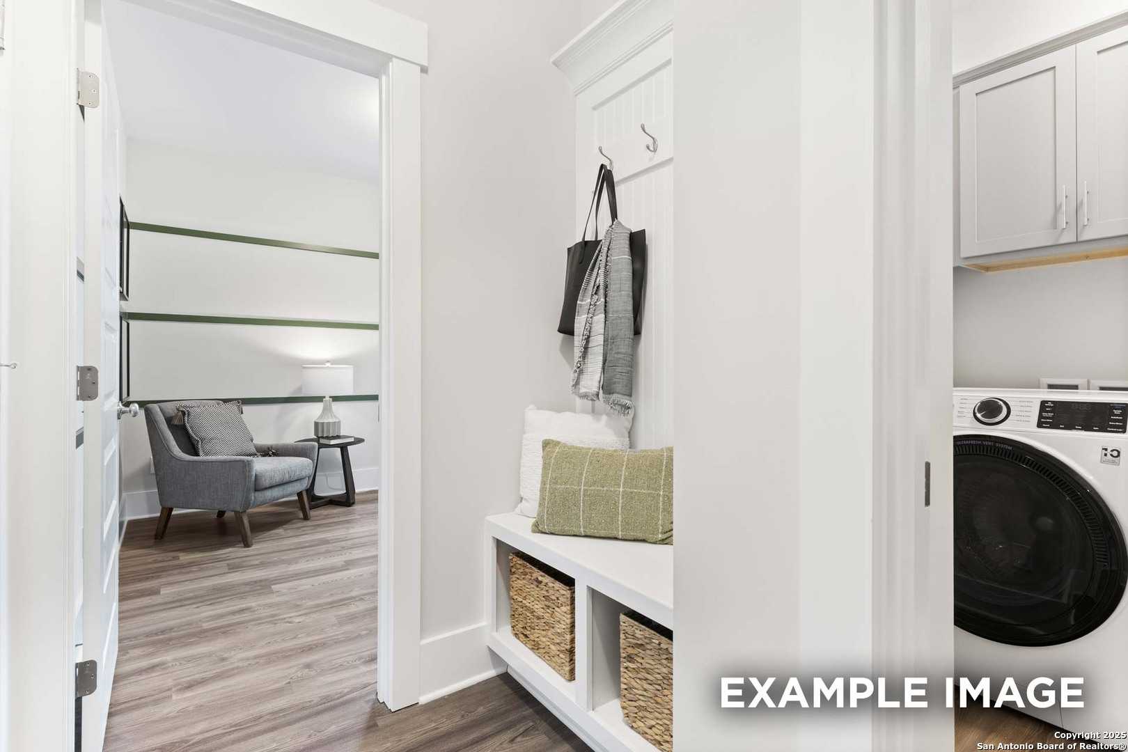 Functional mudroom with built-in bench, coat hooks, and laundry area in Davidson Homes The Daphne H, Seguin, Texas