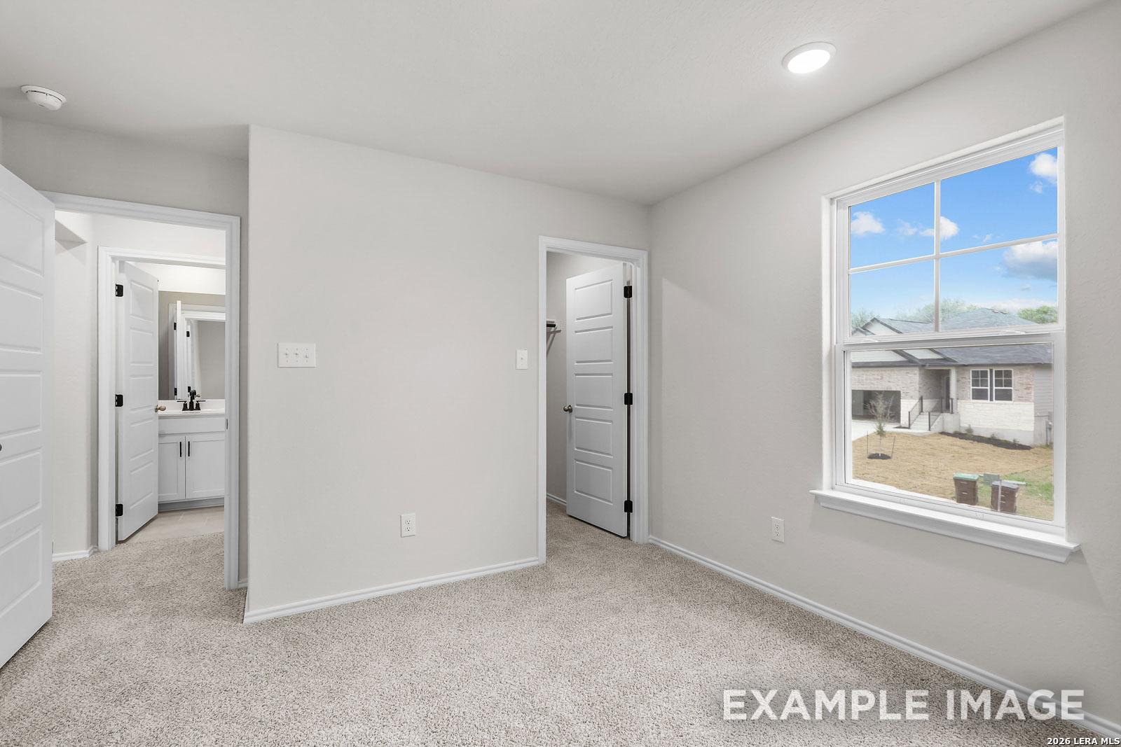 Bright bedroom with walk-in closet and en-suite bathroom in The Sequoia C floor plan, Royal Crest, San Antonio.