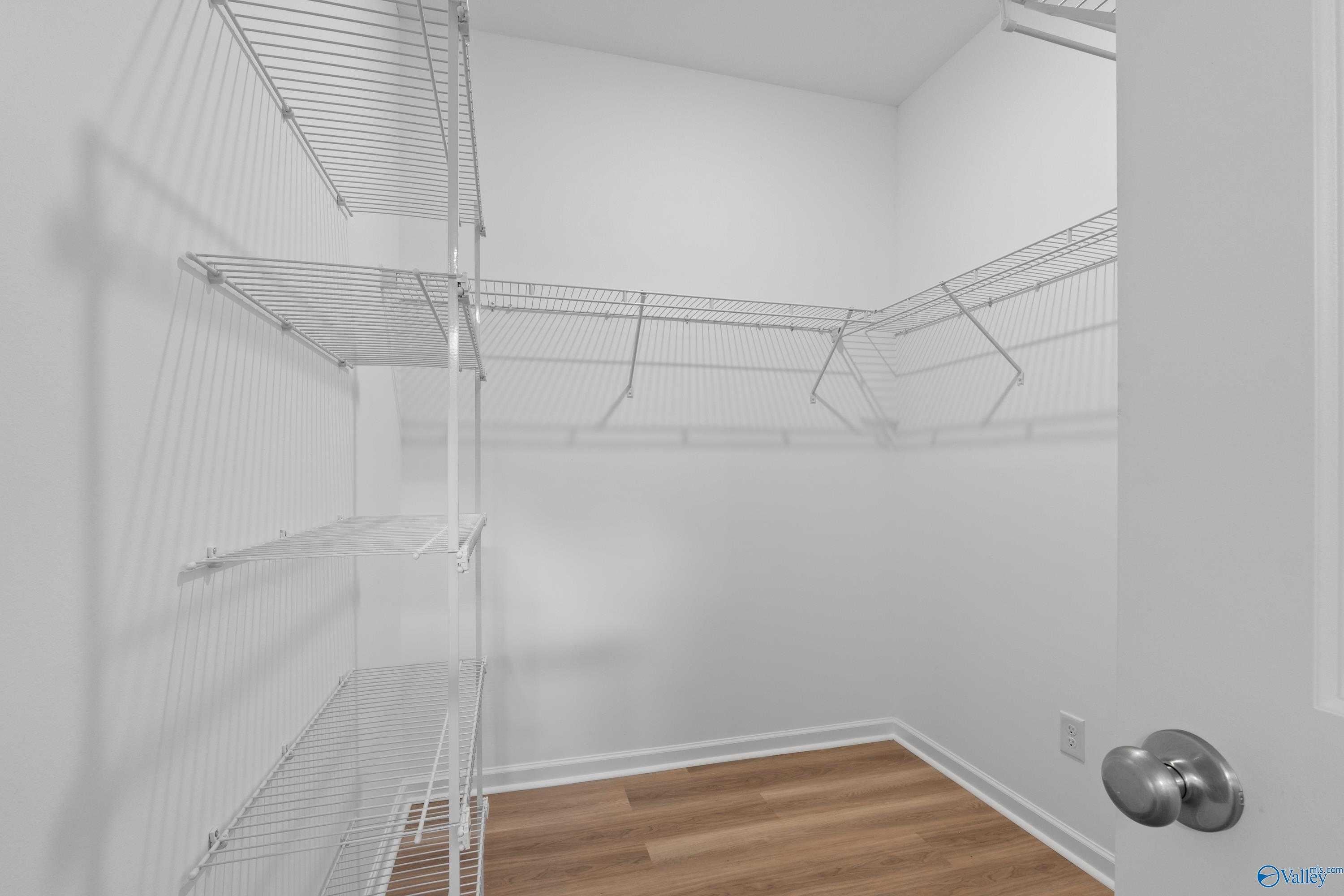 Spacious walk-in closet with white wire shelving and hardwood floors in Davidson Homes The Polaris, Bailey Park, Fayetteville, Tennessee