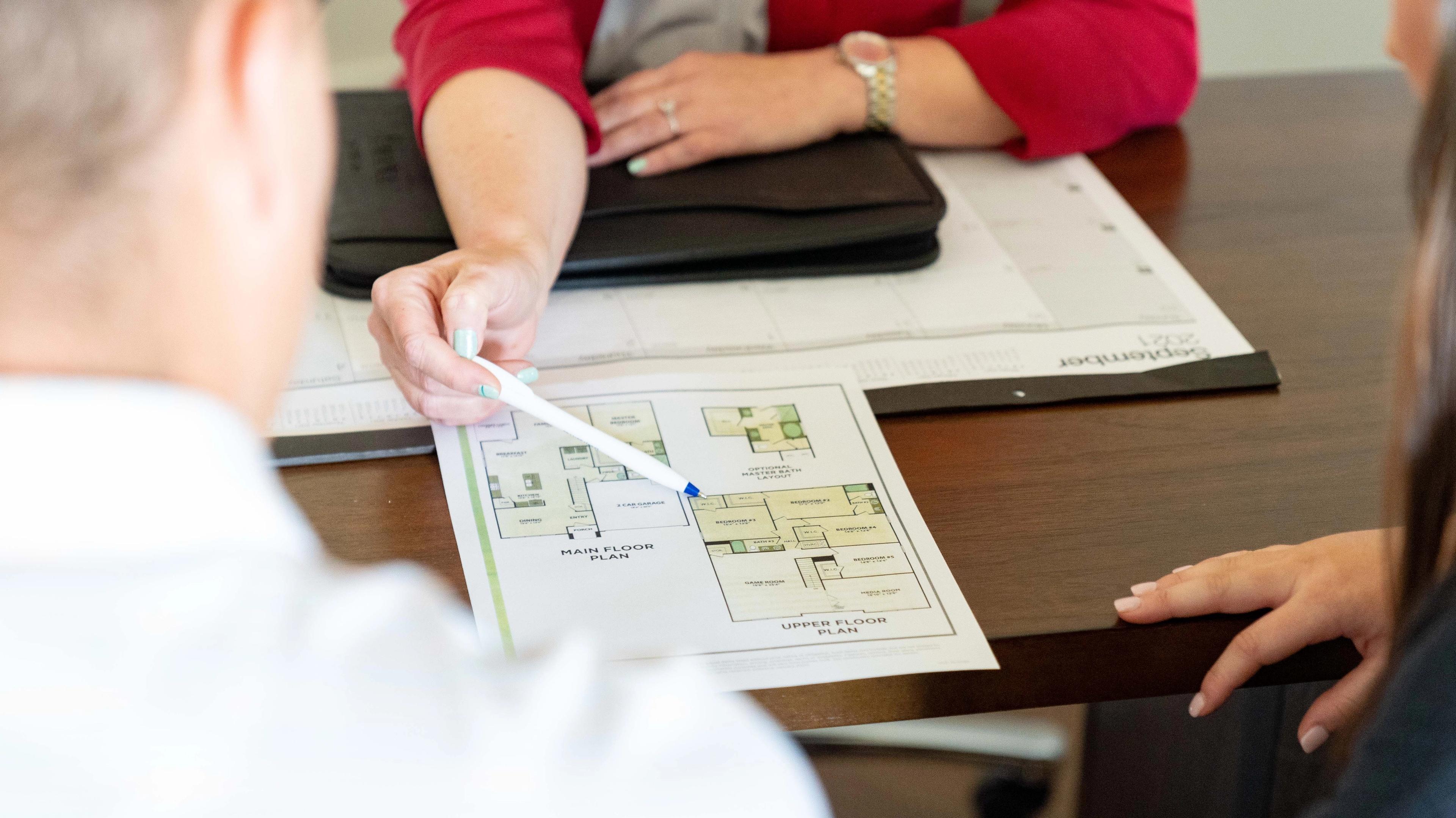 A realtor helps a young couple preparing to buy a home