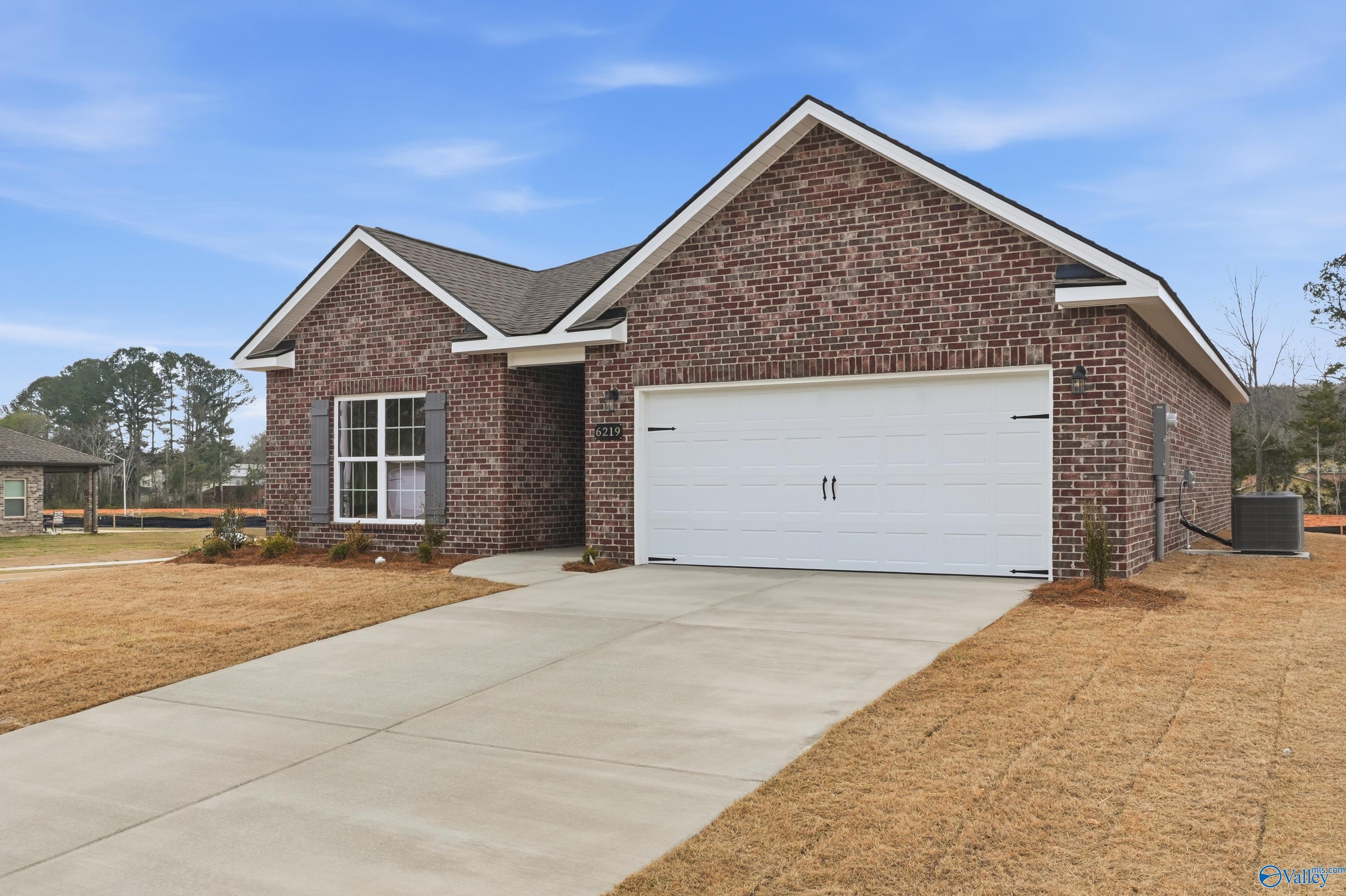 Red brick single-story home with gabled roof, 2-car garage, and driveway in Spragins Cove, Huntsville, Alabama - Davidson Homes Asheville C