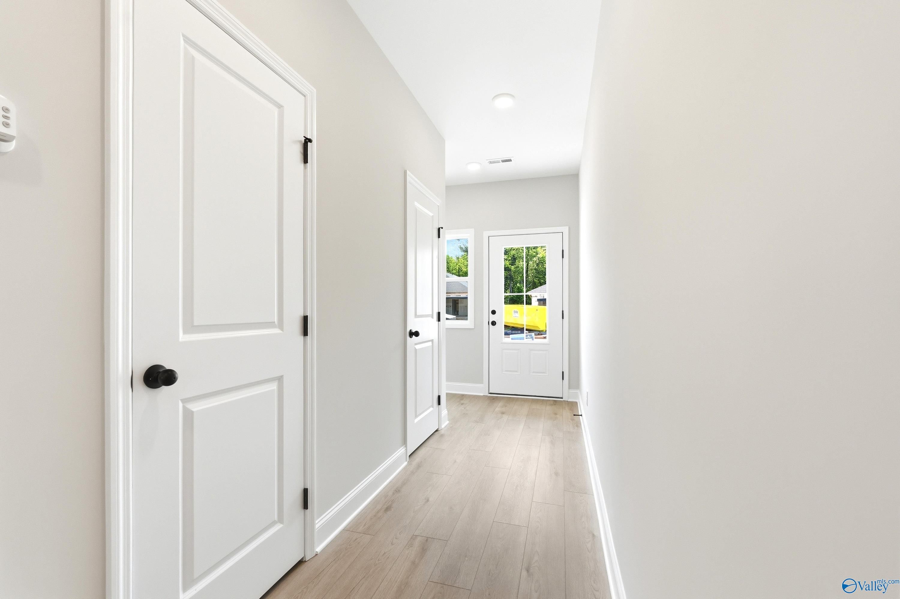 Bright, modern entryway hallway with wood-look flooring in The Russell A floor plan by Davidson Homes in Huntsville, AL.