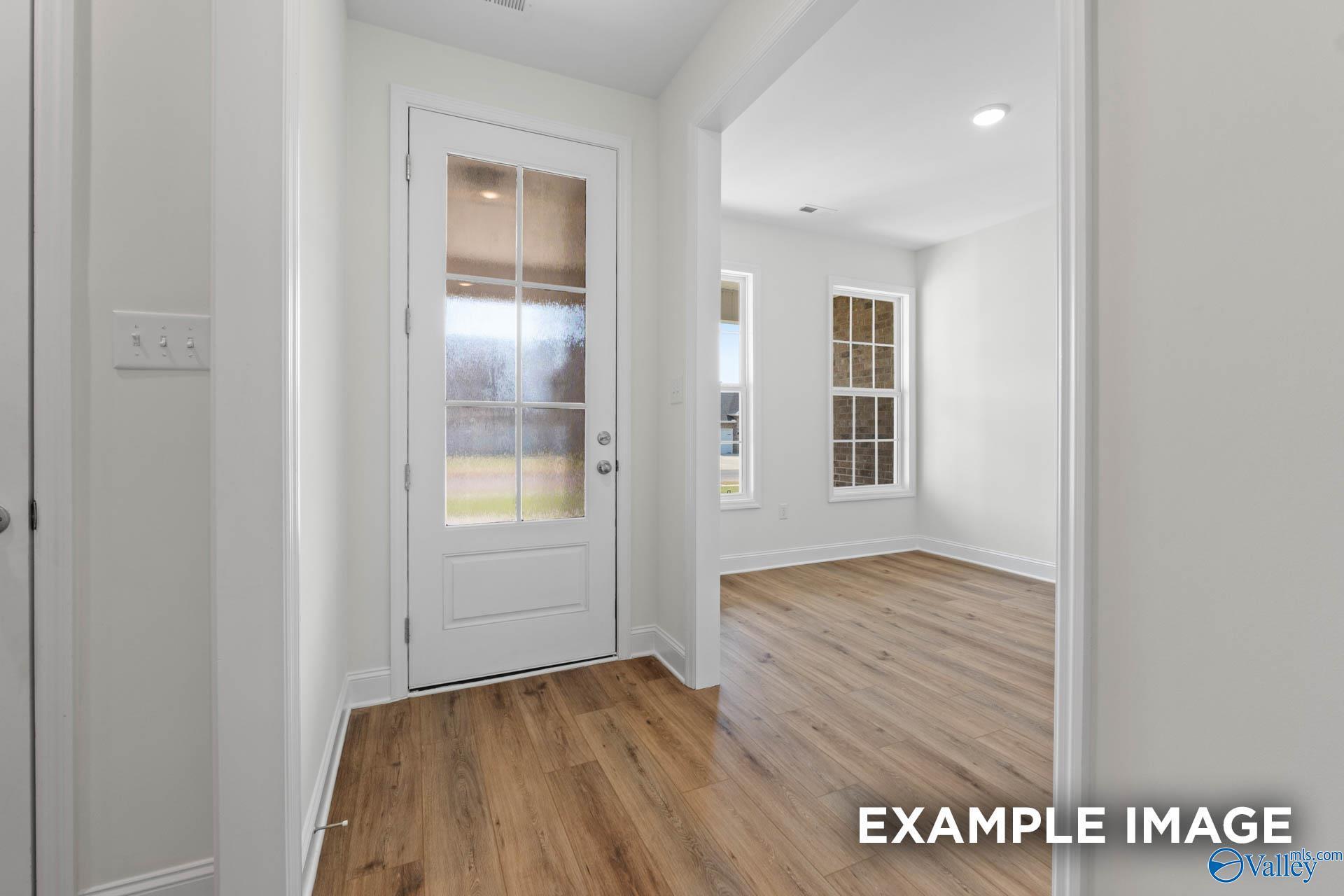 Bright entryway with white glass door, archway, hardwood floors in Davidson Homes Rockford C, Madison, Alabama