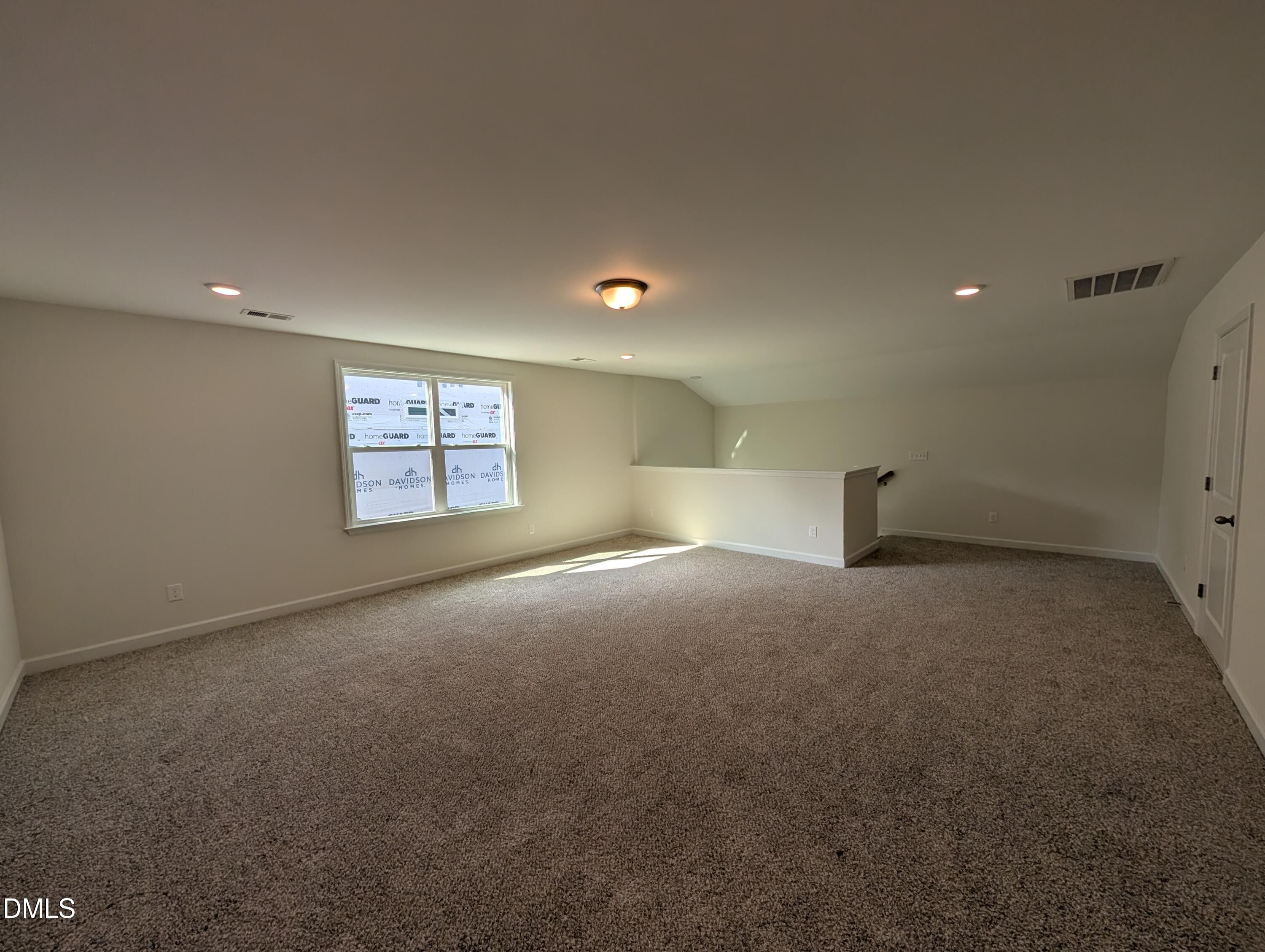 Spacious carpeted upstairs loft with natural light and staircase overlooking below in Davidson Homes Magnolia A, Wendell Ridge, NC