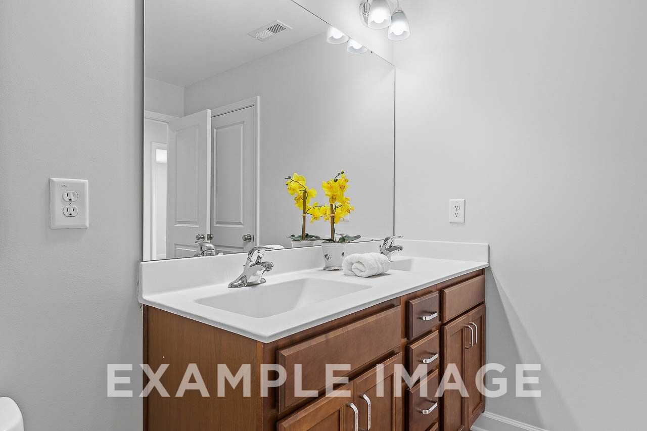 Davidson Homes The Chestnut Plan Bathroom with Wood Vanity and Mirror