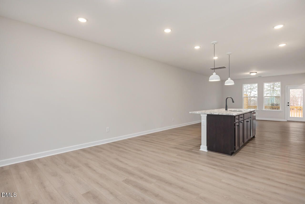 Modern open-concept kitchen with quartz island, dark cabinets, and large windows in 4-bedroom Davidson Homes The Mitchell, Knightdale, NC
