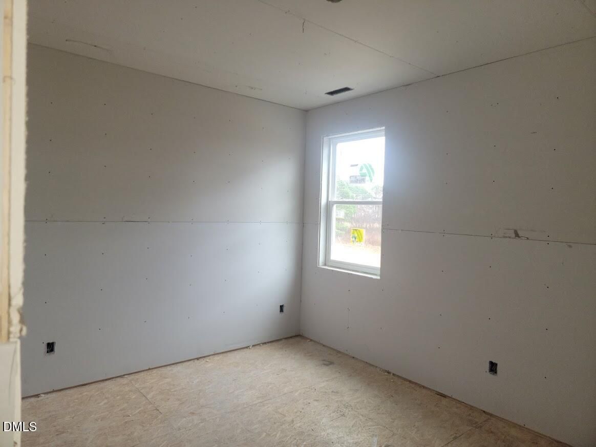 Unfinished bedroom with drywall walls, window, and outlets in new Ashport G home by Davidson Homes, Angier, NC