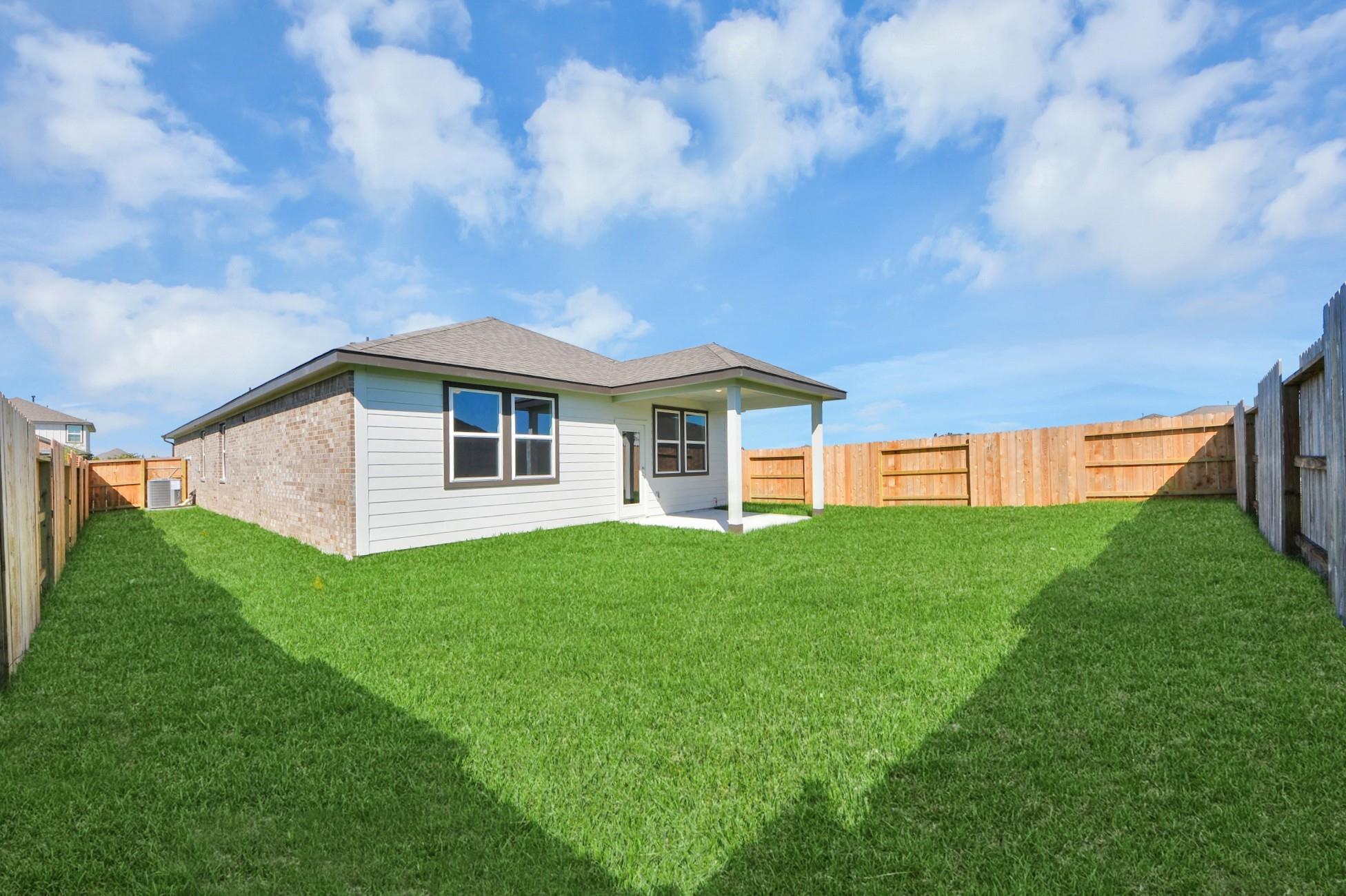 Private backyard with covered patio at The Colorado G floor plan by Davidson Homes in Emberly, Beasley, Texas.