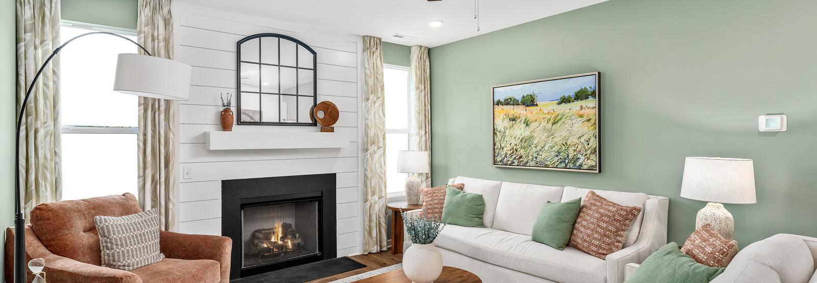 Cozy living room in Calista Farms White House TN with sage green walls gas fireplace white sofa and ceiling fan