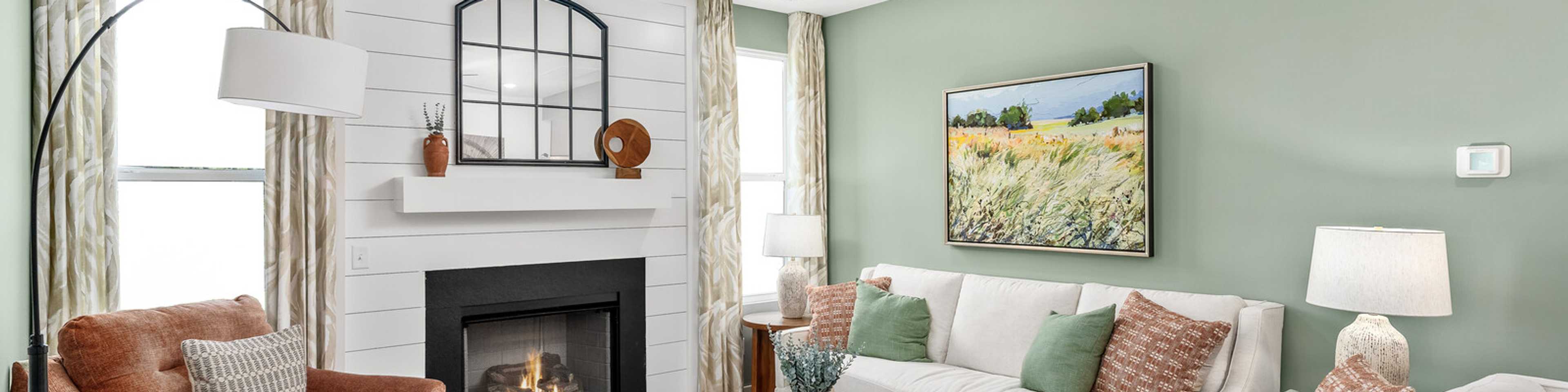Cozy living room in Calista Farms White House TN with sage green walls gas fireplace white sofa and ceiling fan