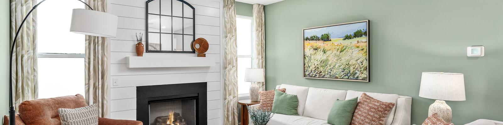 Cozy living room in Calista Farms White House TN with sage green walls gas fireplace white sofa and ceiling fan