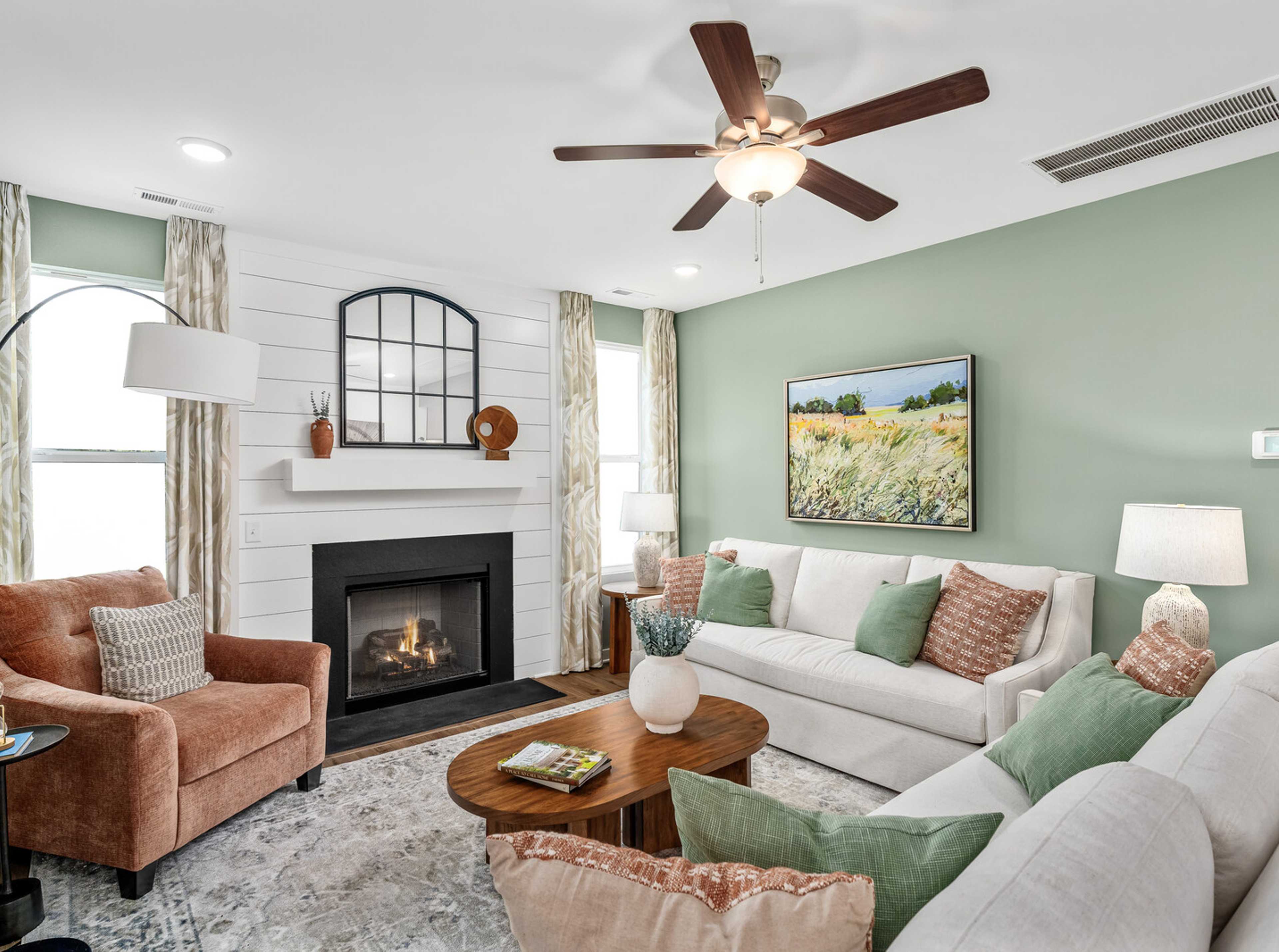 Cozy living room in Calista Farms White House TN with sage green walls gas fireplace white sofa and ceiling fan