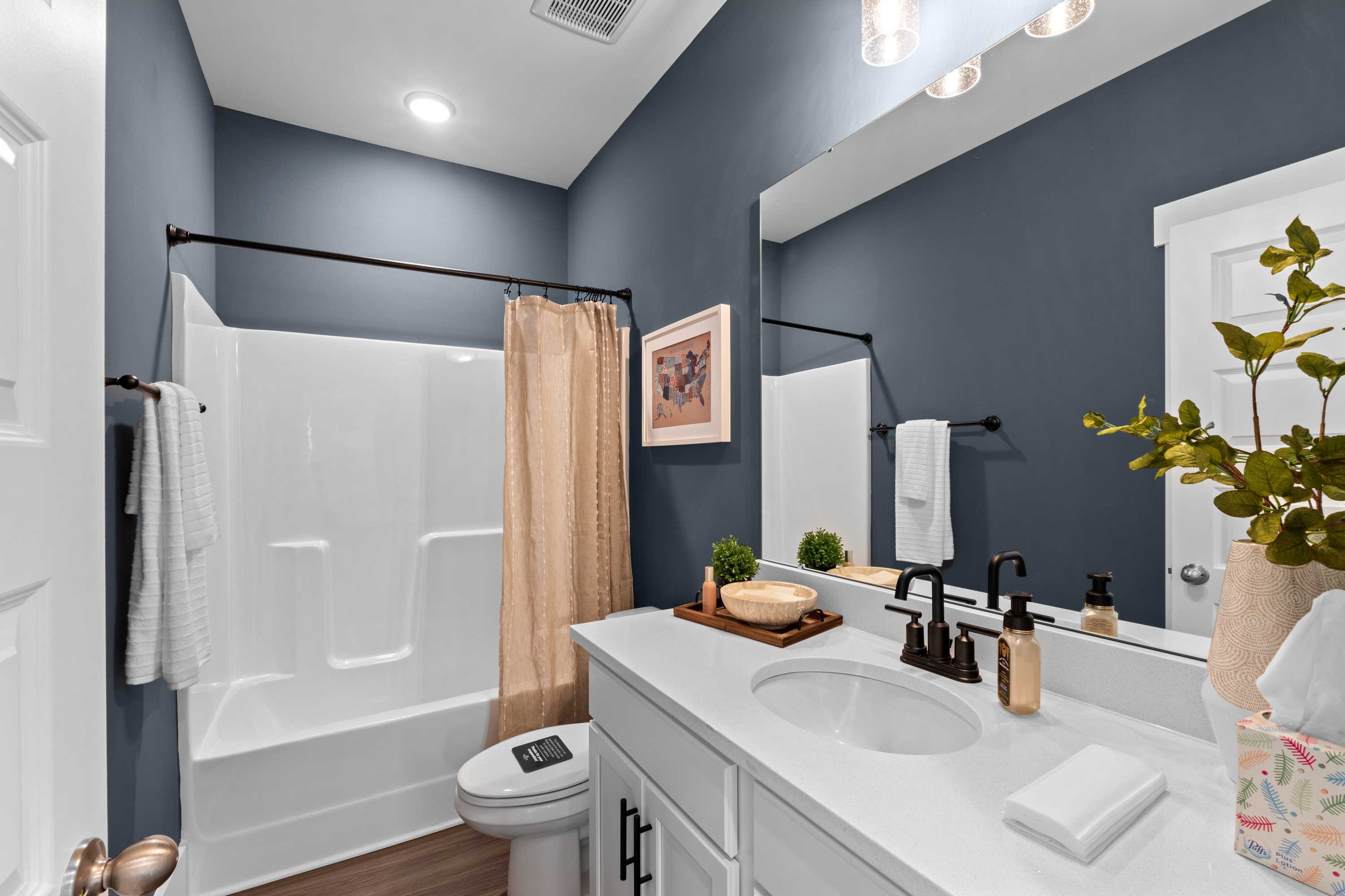 Modern bathroom at Ivy Hills in Toney Alabama with navy walls white vanity subway tile shower and hardwood floors
