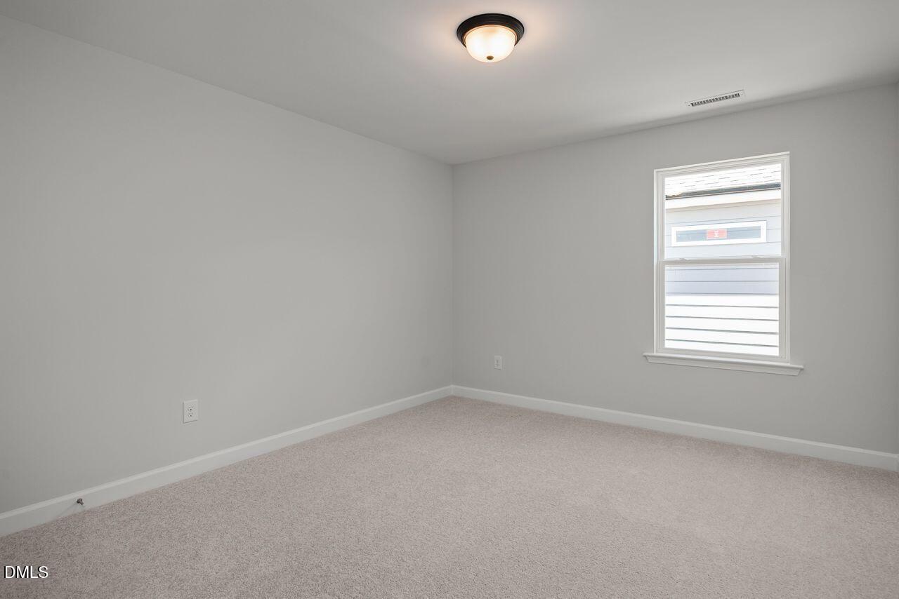 Spacious bedroom with neutral carpet and natural light in The Birch II A floor plan at Montrose in Aberdeen, North Carolina.