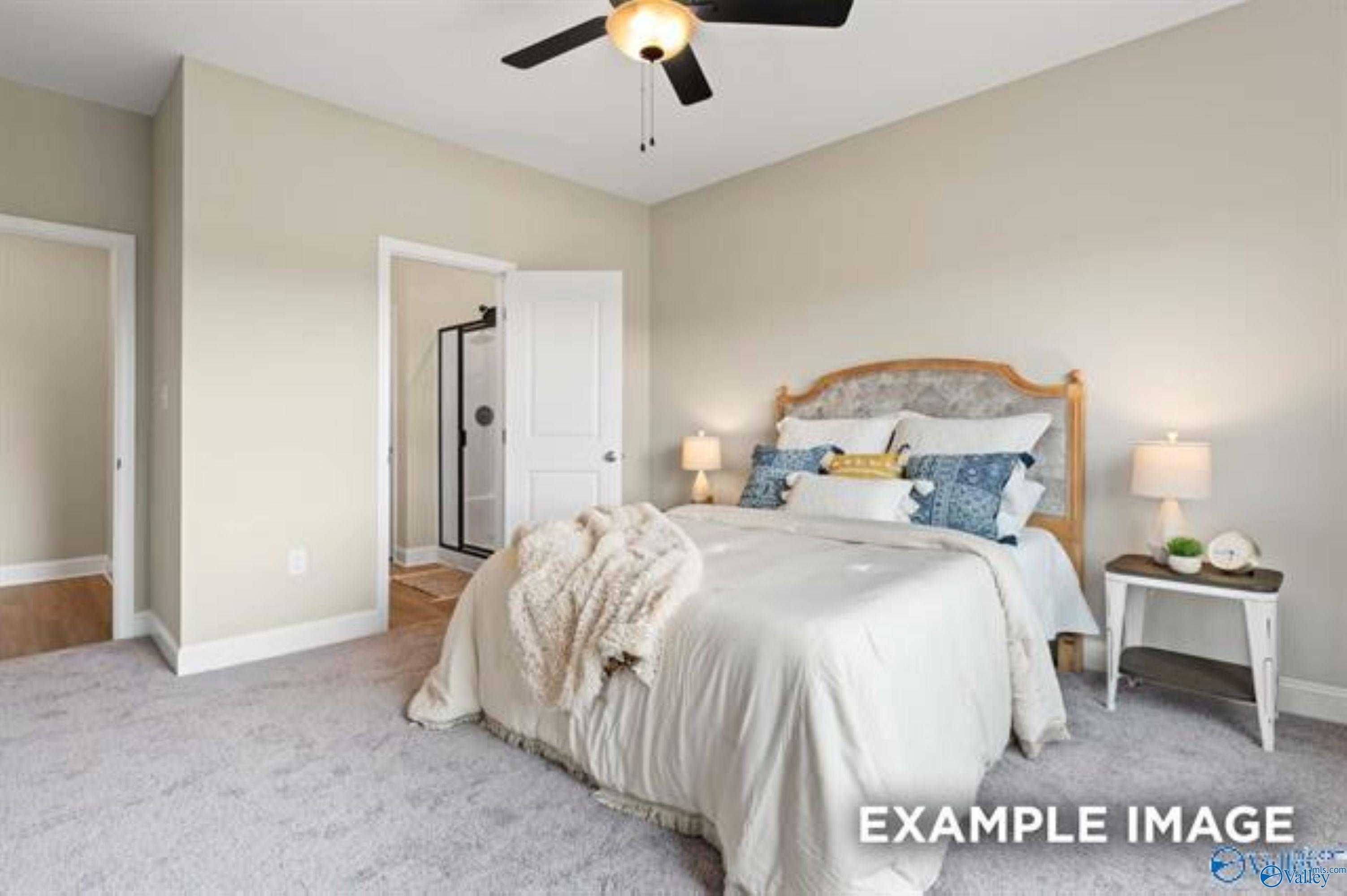Elegant master bedroom with upholstered king bed, ceiling fan, and en-suite glass shower in Davidson Homes The Asheville, Owens Cross Roads