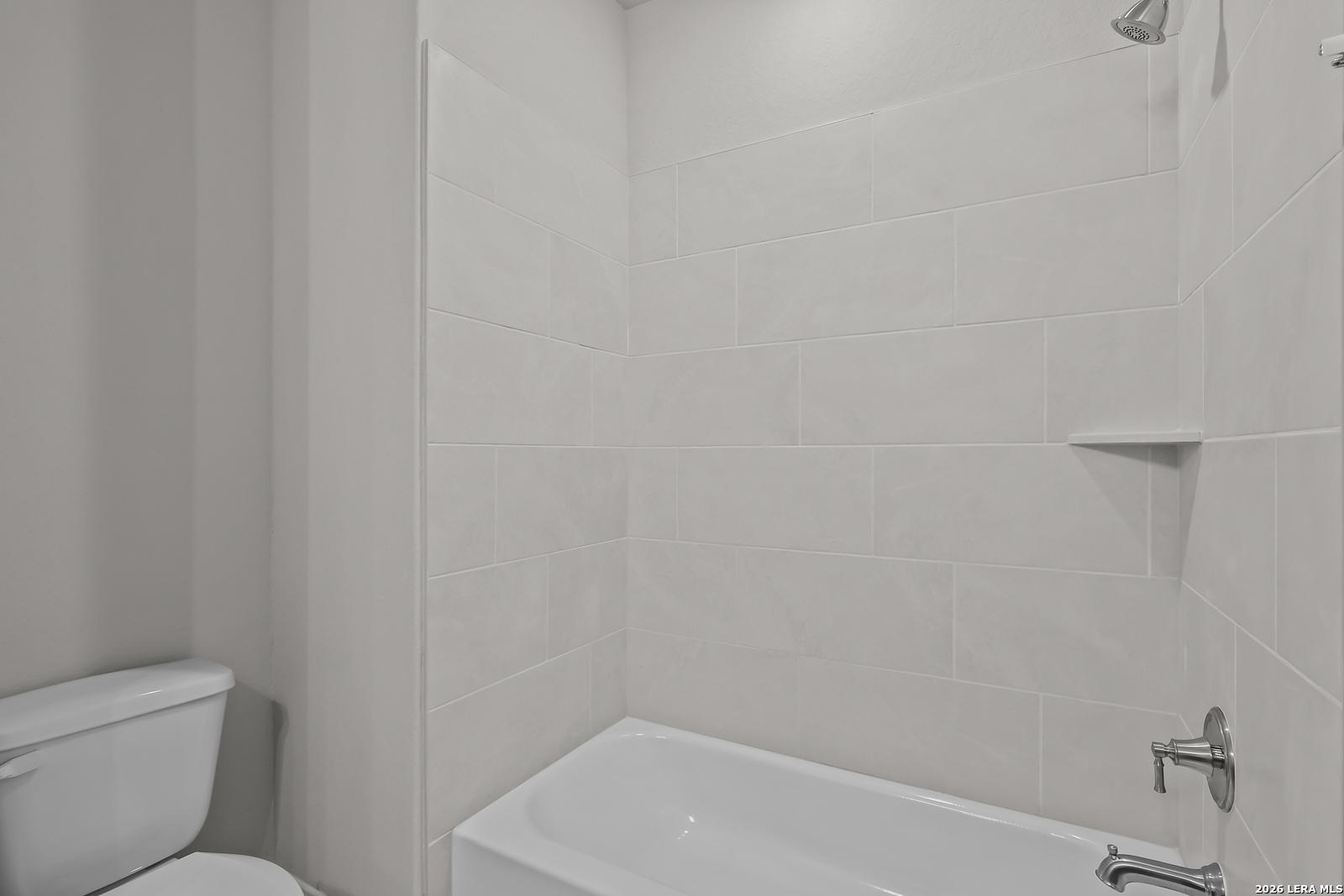Modern white-tiled shower and corner soaking tub in master bathroom, Davidson Homes The Rockford G, Ladera, San Antonio