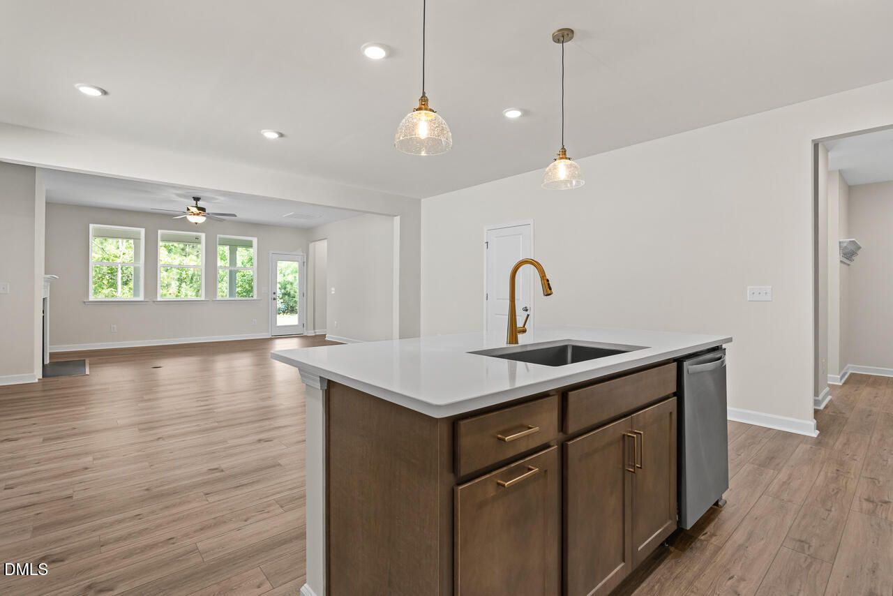 Kitchen island with gold faucet and pendant lights in Davidson Homes Birch II C new home, Sage on North Main, Wake Forest, NC