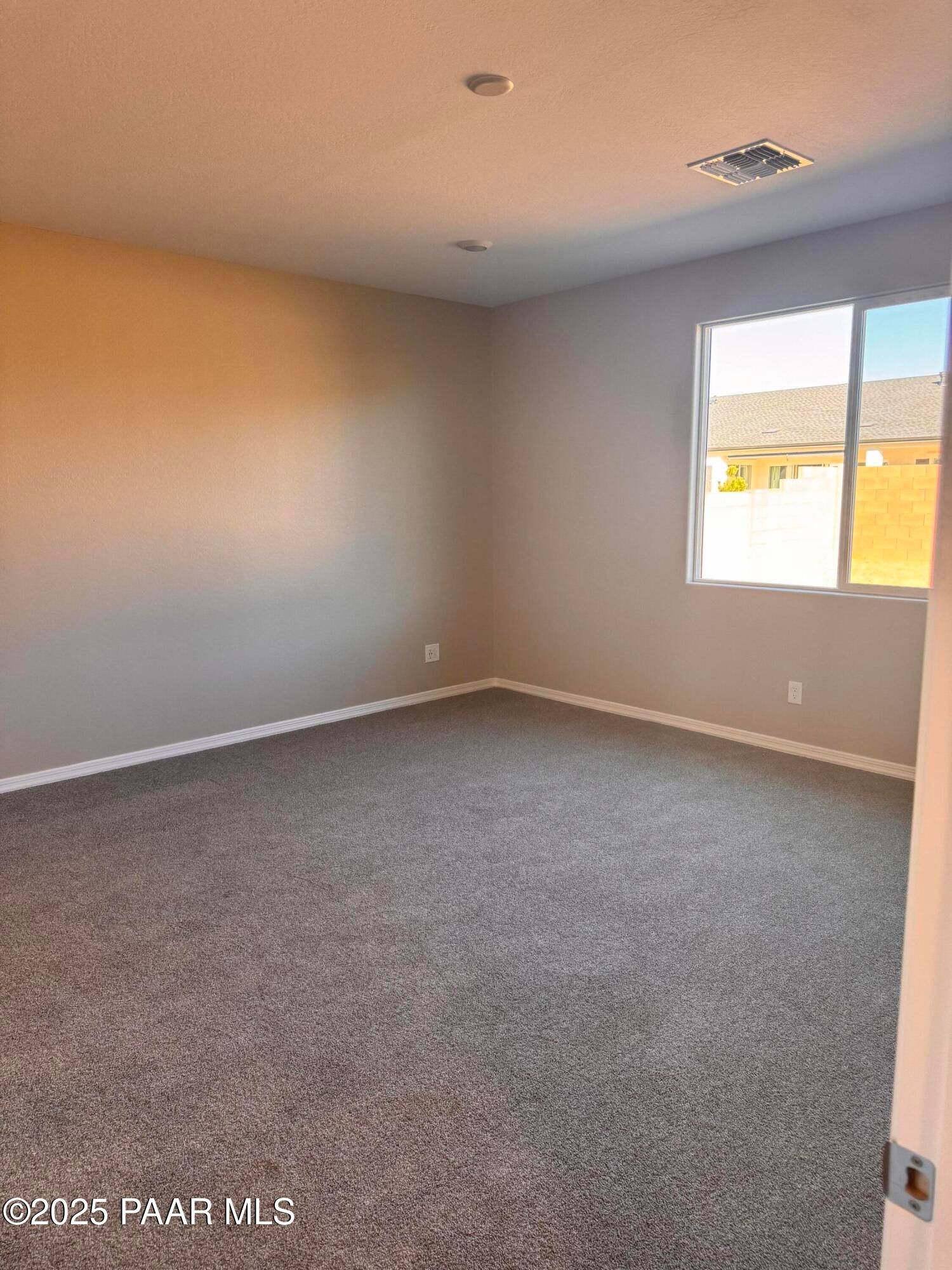 Empty bedroom featuring gray carpet, neutral walls, large window with neighborhood view in Davidson Homes The Sunrise II A, Prescott, Arizona
