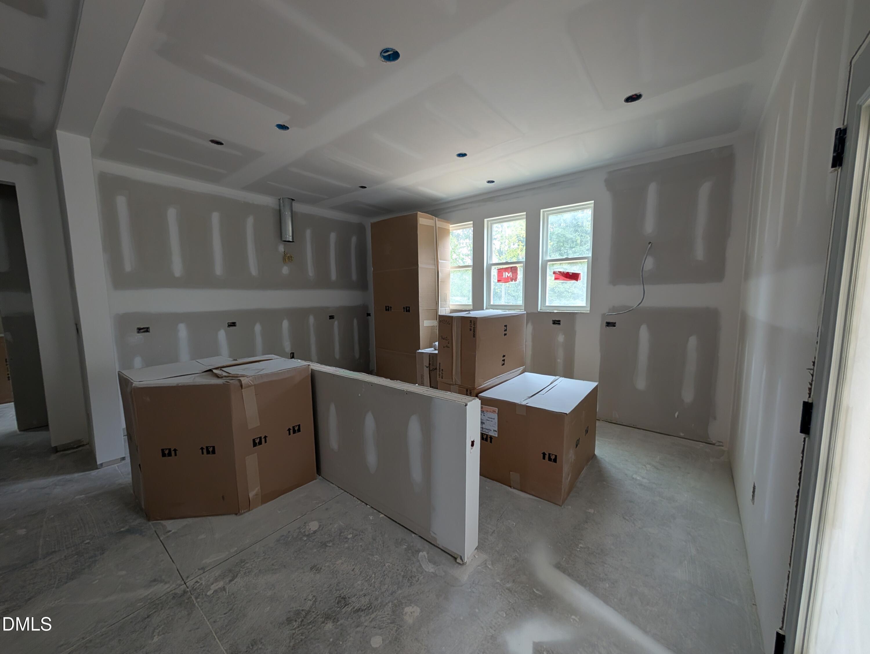 Unfinished kitchen under construction with cabinetry boxes and coffered ceiling in The Aspen C by Davidson Homes, Wendell Ridge, NC