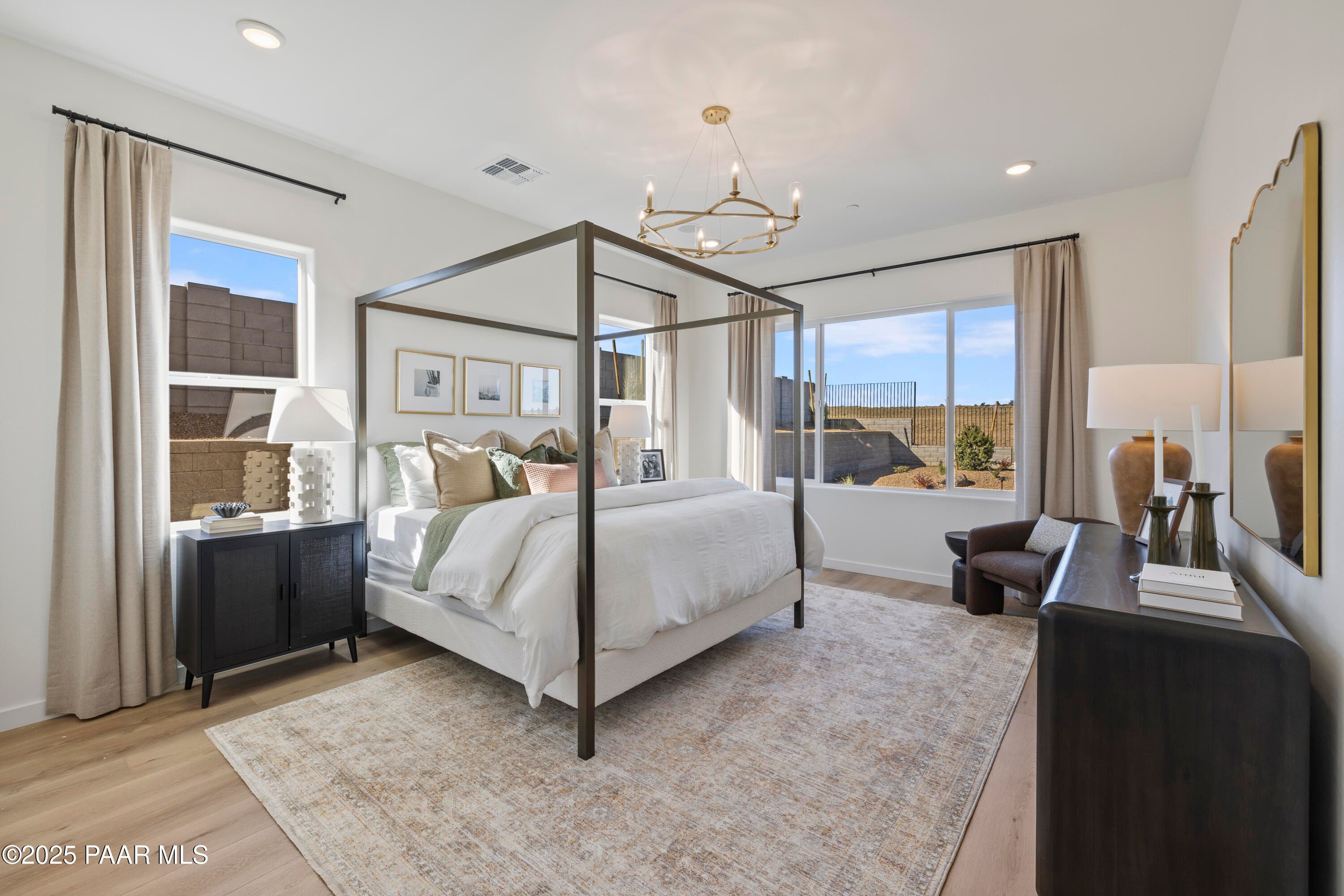Elegant master bedroom with canopy king bed, chandelier, and desert views in Davidson Homes The Blaze D, Prescott, AZ