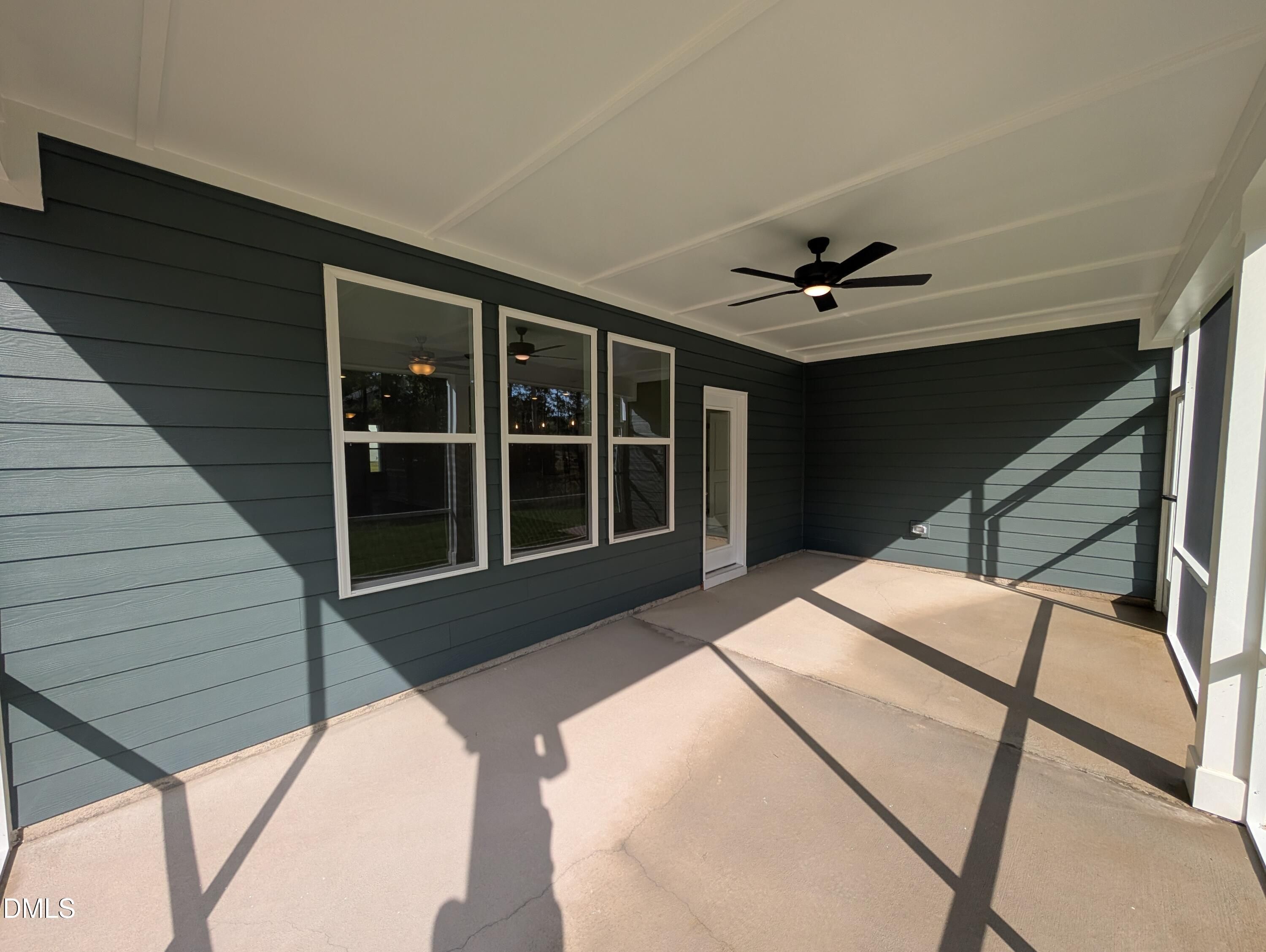 Covered patio with ceiling fan and blue siding at Davidson Homes The Magnolia A in Wendell Ridge, Wendell, North Carolina