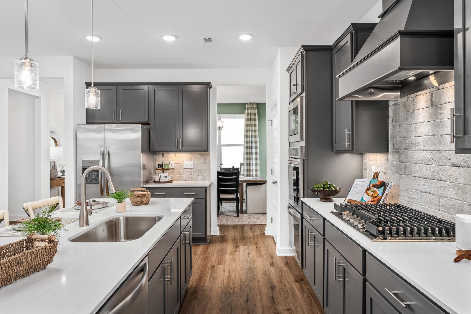 Spacious modern kitchen in Calista Farms White House TN with gray cabinets white quartz island stainless appliances