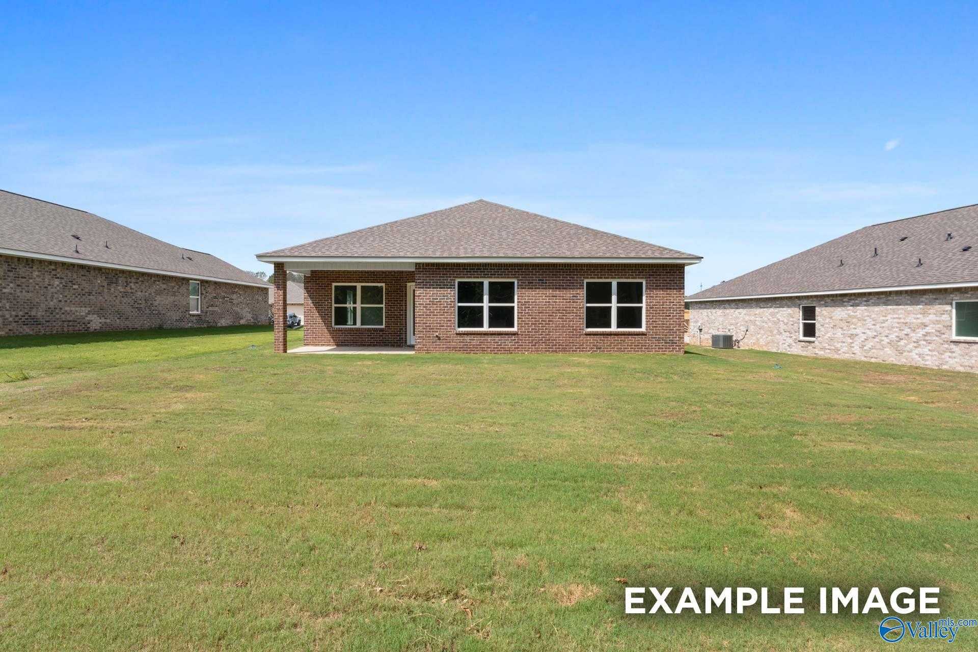 Brick single-story 3-bedroom home with gabled roof, large windows, and covered entry on lush lawn in Lynn Meadows, Meridianville, Alabama