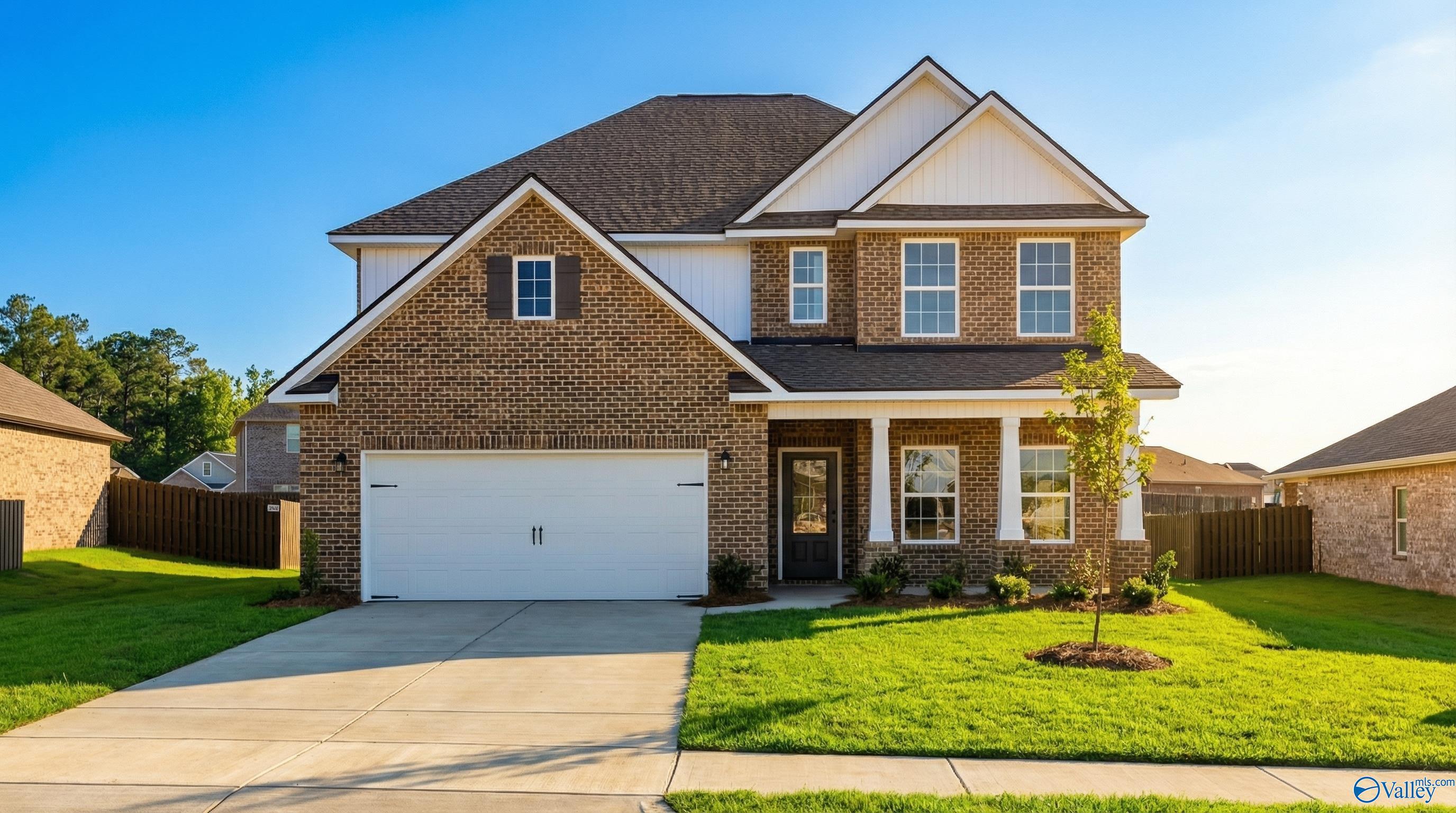 Two-story brick home with 2-car garage, covered porch, and lush lawn in Creekside, Harvest, Alabama by Davidson Homes