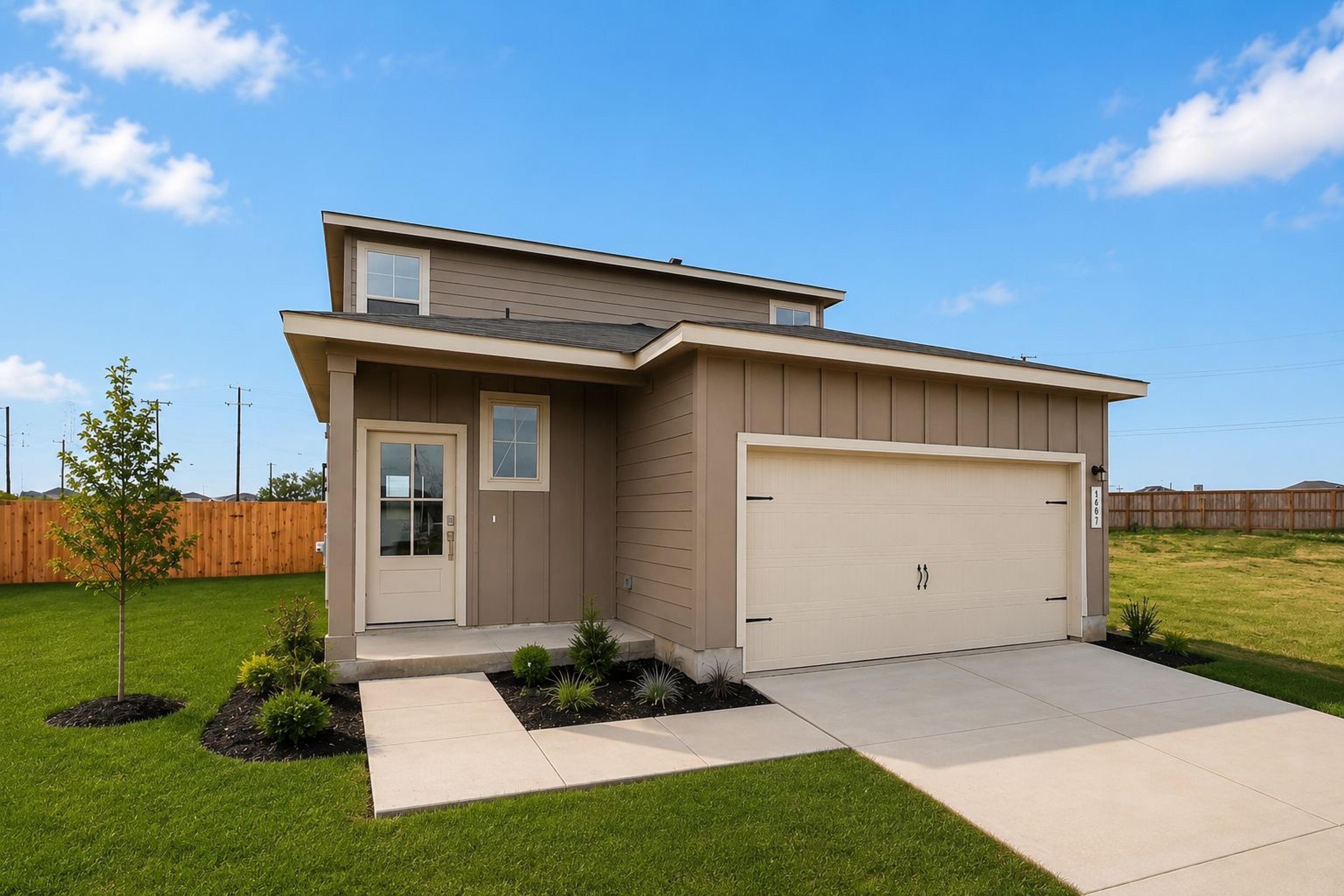 Modern home exterior at Agave in San Antonio, Texas by Davidson Homes with a two-car garage and landscaped front yard.