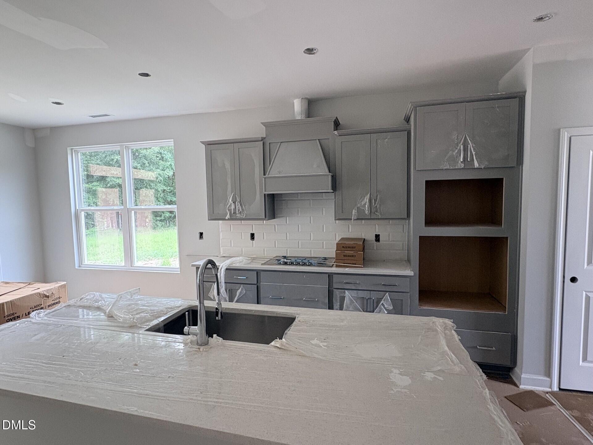 New kitchen construction with gray cabinets and island in The Ash C floor plan at Woodland Crossing, Zebulon, North Carolina.