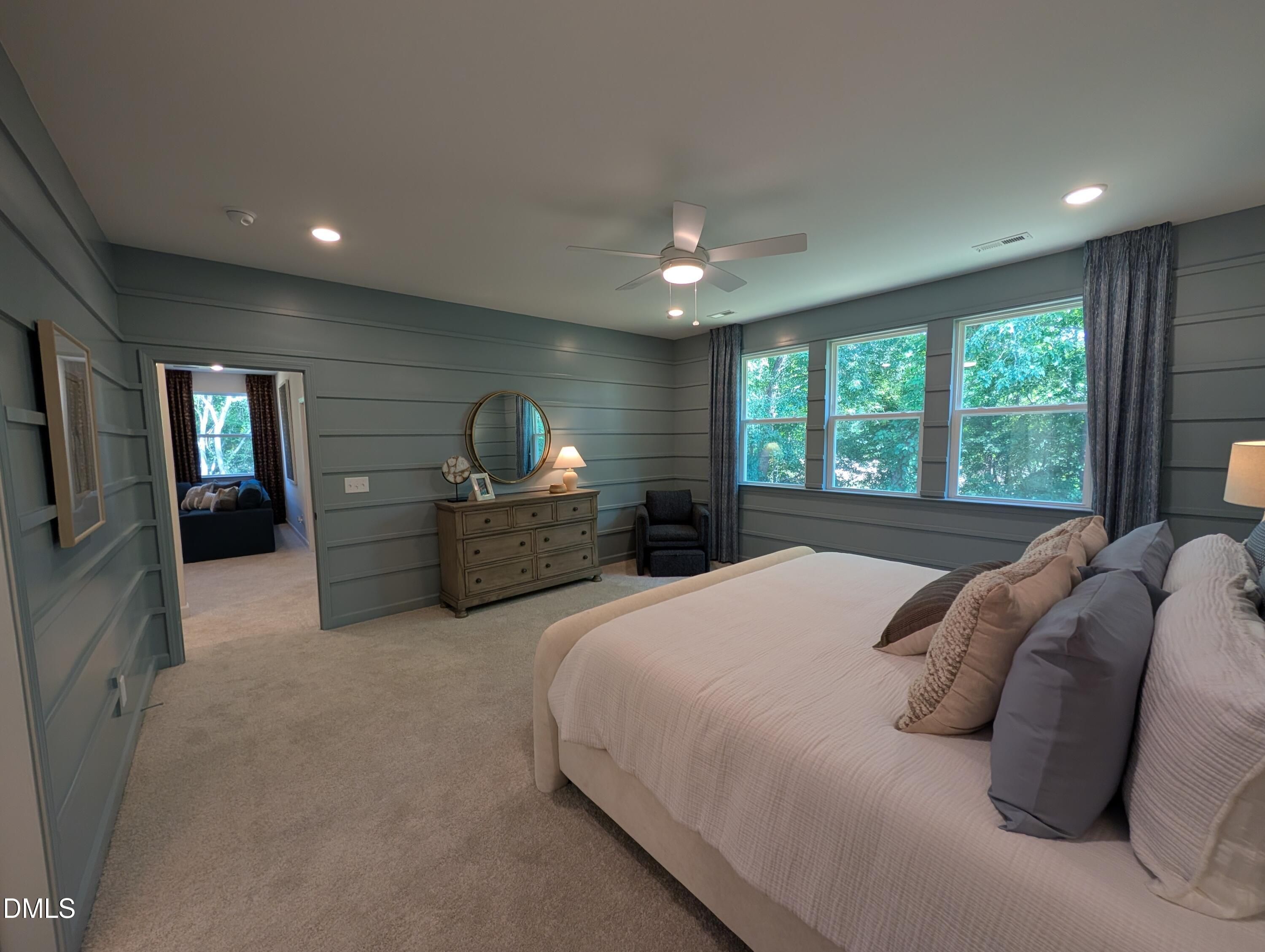 Spacious primary bedroom with blue shiplap walls and carpet in The Aspen B floor plan at Wendell Ridge, North Carolina.